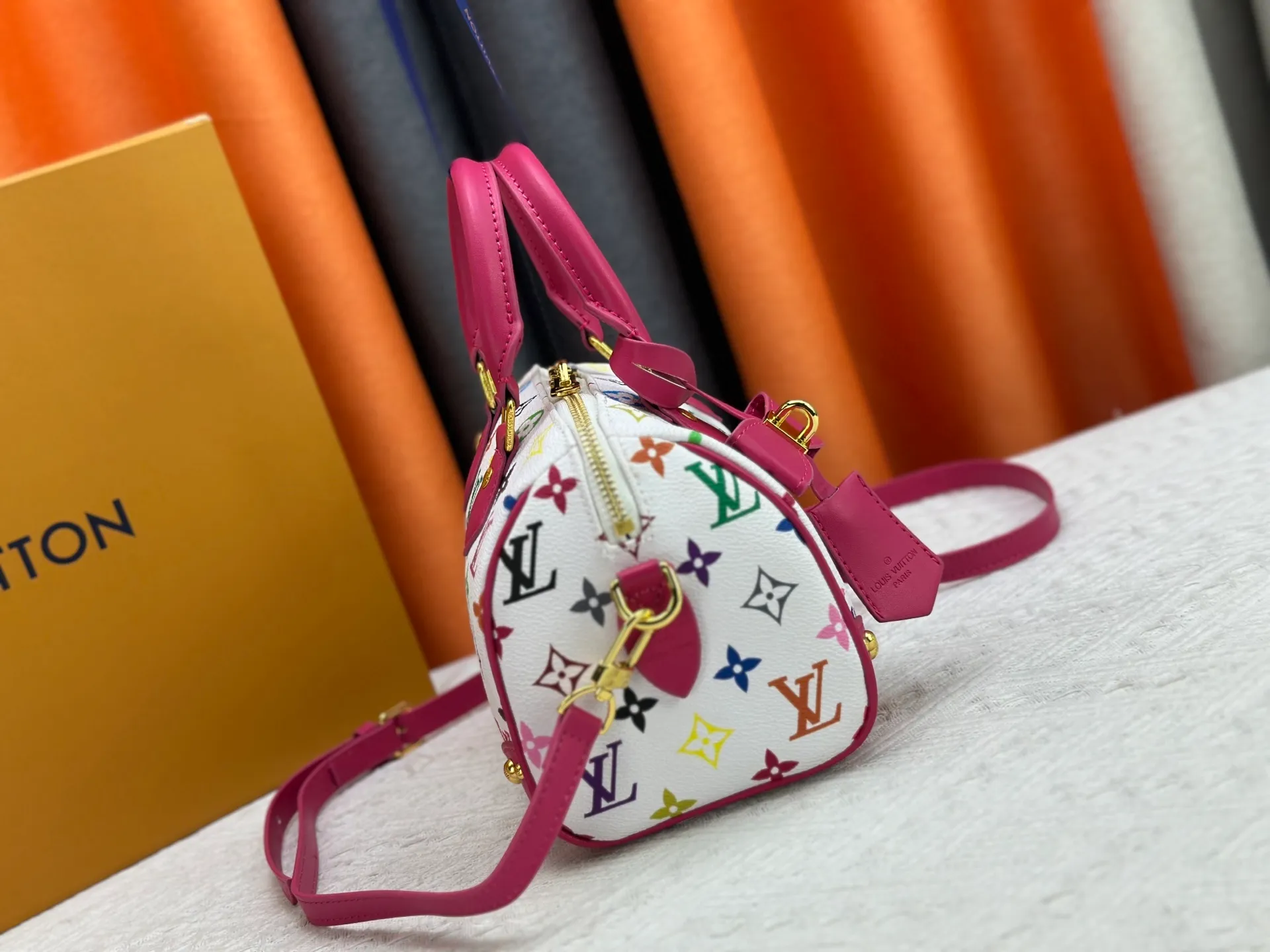 P260 upgraded original M58953 M46234 M46222 Speedy Bandoulière 20 handbag is made of soft coated canvas, and the full-length Monogram pattern is traced in colorful rainbow tones, highlighting the smart style of the Louis Vuitton x Murakami reissue series. The Toron handle and detachable shoulder strap are constructed of cow leather, the metal corners recall classic luggage elements, and the bow-shaped key bag and padlock add brand touches. Dimensions: 20.5 x 13.5 x 12.0 cm (length x height x width)