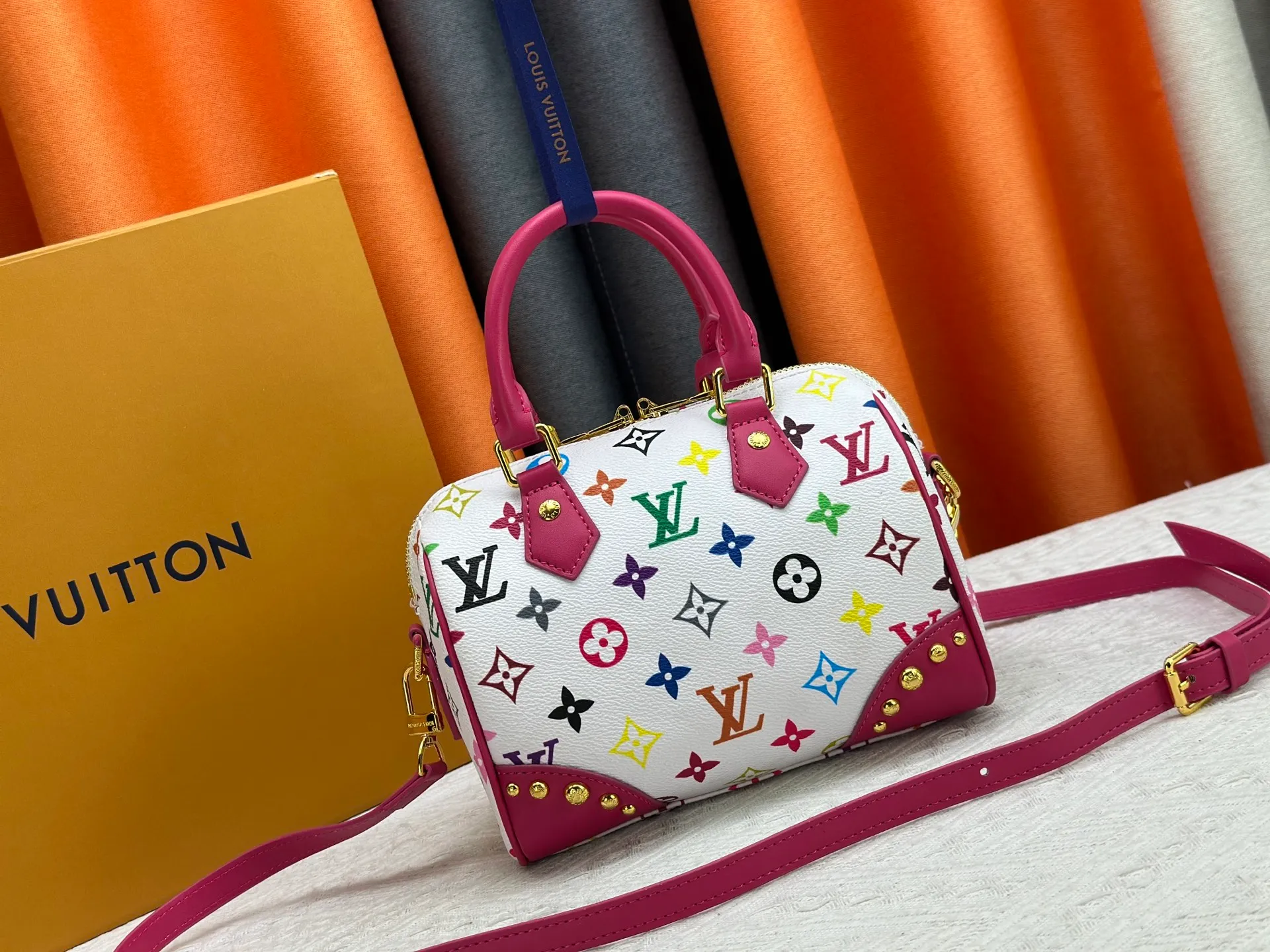 P260 upgraded original M58953 M46234 M46222 Speedy Bandoulière 20 handbag is made of soft coated canvas, and the full-length Monogram pattern is traced in colorful rainbow tones, highlighting the smart style of the Louis Vuitton x Murakami reissue series. The Toron handle and detachable shoulder strap are constructed of cow leather, the metal corners recall classic luggage elements, and the bow-shaped key bag and padlock add brand touches. Dimensions: 20.5 x 13.5 x 12.0 cm (length x height x width)