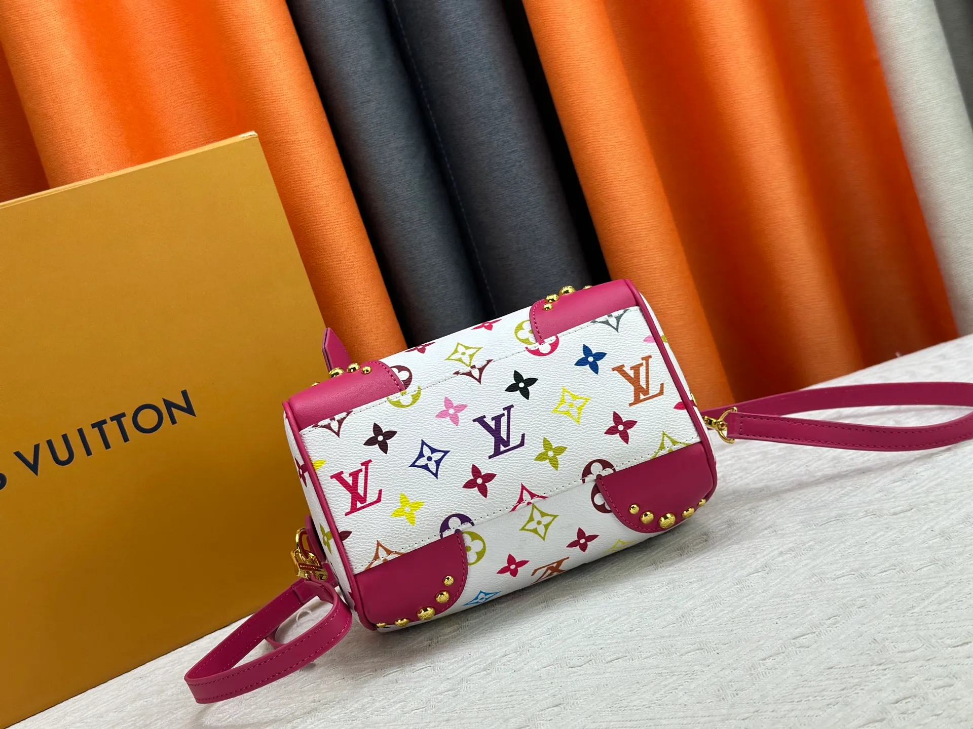 P260 upgraded original M58953 M46234 M46222 Speedy Bandoulière 20 handbag is made of soft coated canvas, and the full-length Monogram pattern is traced in colorful rainbow tones, highlighting the smart style of the Louis Vuitton x Murakami reissue series. The Toron handle and detachable shoulder strap are constructed of cow leather, the metal corners recall classic luggage elements, and the bow-shaped key bag and padlock add brand touches. Dimensions: 20.5 x 13.5 x 12.0 cm (length x height x width)