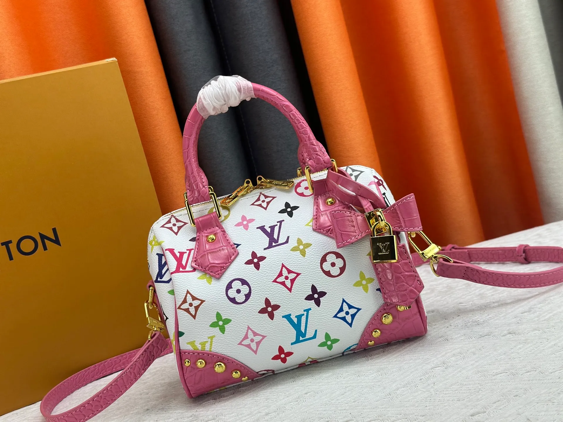 P260 Upgraded original crocodile pattern M13365 M58953 M46234 M46222 Speedy Bandoulière 20 handbag is made of soft coated canvas, and the full-length Monogram pattern is traced in colorful rainbow tones, highlighting the smart style of the Louis Vuitton x Murakami reissue series. The Toron handle and detachable shoulder strap are constructed of cow leather, the metal corners recall classic luggage elements, and the bow-shaped key bag and padlock add brand touches. Dimensions: 20.5 x 13.5 x 12.0 cm (length x height x width)