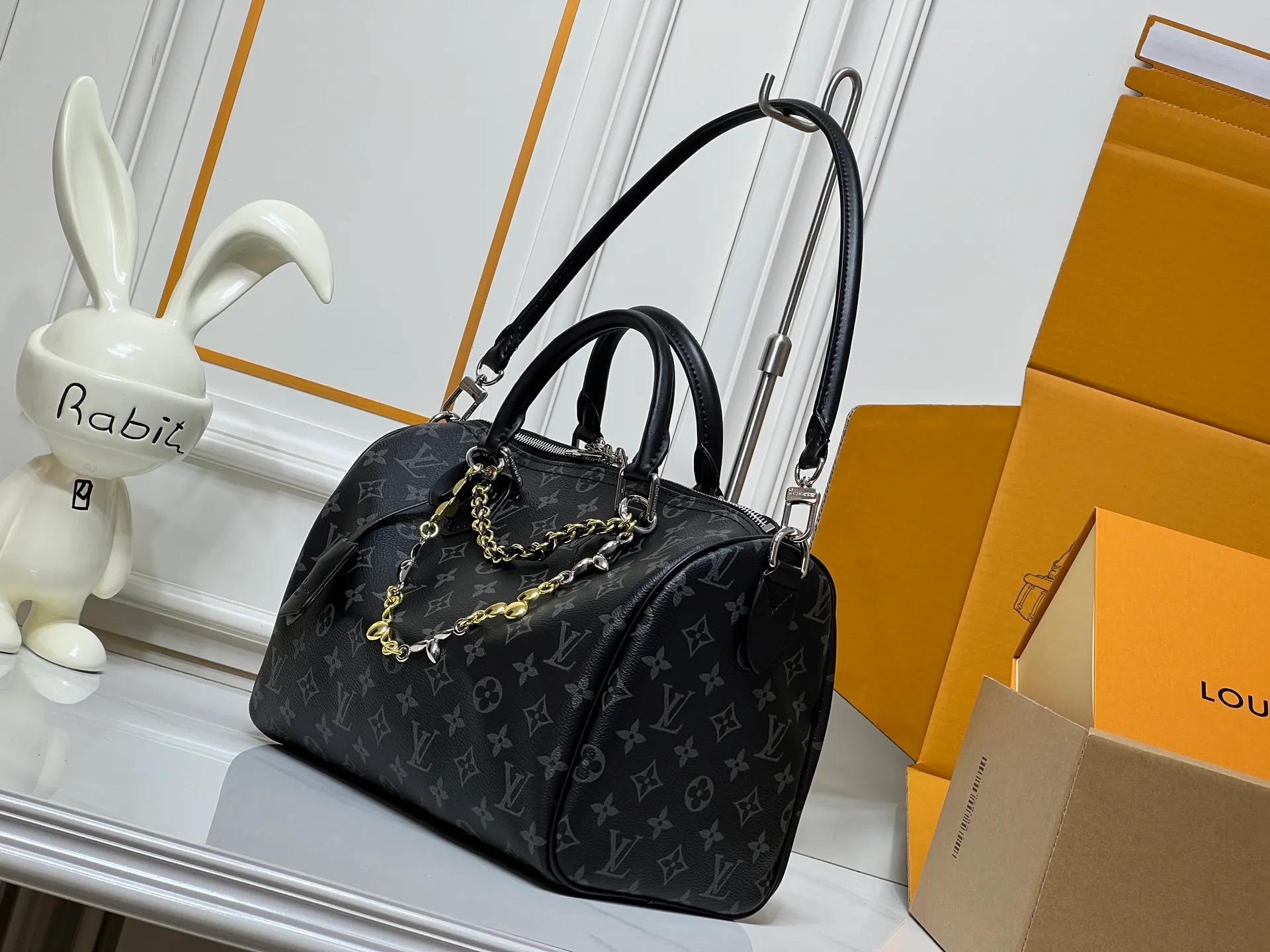 Batch 320💰M15102 black flower M15107 presbyopia M15108 dune white This Speedy Soft 30 handbag comes from the LV Ski series and uses Monogram Eclipse canvas to renew the classic design. Double chains, a pleated leather key fob and a signature padlock add to the luxe details, and it's just the right size to hold a tablet and other everyday essentials.  21 x 17 x 30 cm (H x W x L) Monogram Eclipse pattern Coated canvas Cow leather trim Grained cow leather lining Glossy and shiny hardware Double zipper closure Internal zip pocket Detachable double chain Key case Holds 9" tablet, 6.7" smartphone, headphones, Zippy wallet, keys, sunglasses and lipstick Shoulder strap: removable, non-adjustable Strap half length: 24.0 cm Handle: double handle