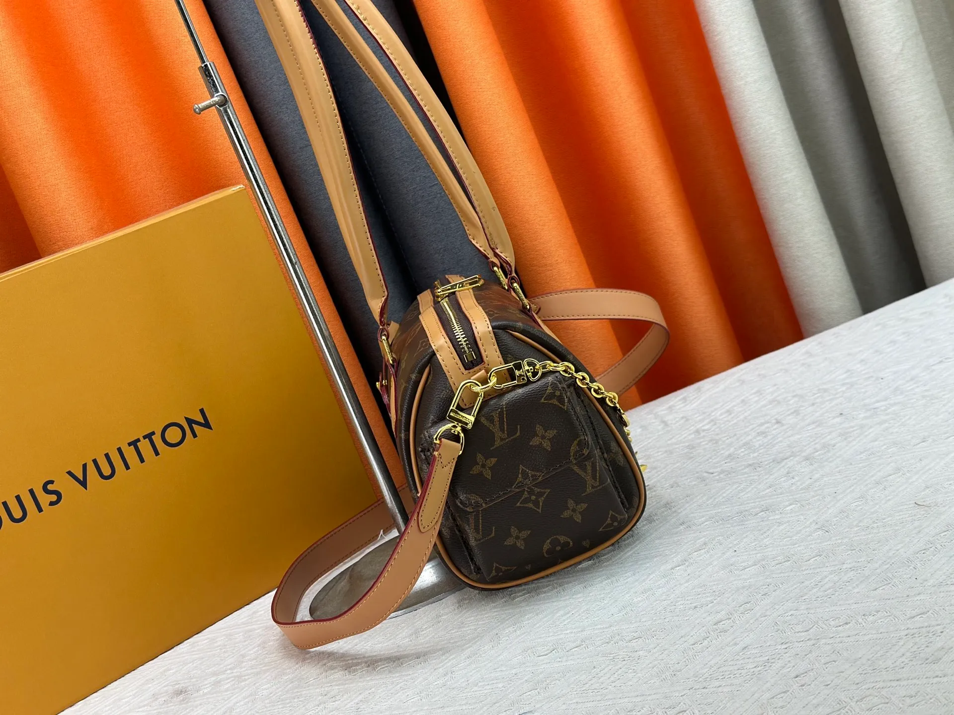 P300 Upgraded original M12934 M12965 This Speedy Cargo handbag is from the LV Vibe series, renovating the classic design of the 1930s with avant-garde touches. The glossy sheepskin body is embellished with a Monogram address plate, paying tribute to the brand's long trunk-making heritage. Plenty of space to easily store your daily needs, and the detachable leather shoulder strap allows for a variety of carrying methods. Dimensions: 28 x 17 x 12 cm (LxHxW)