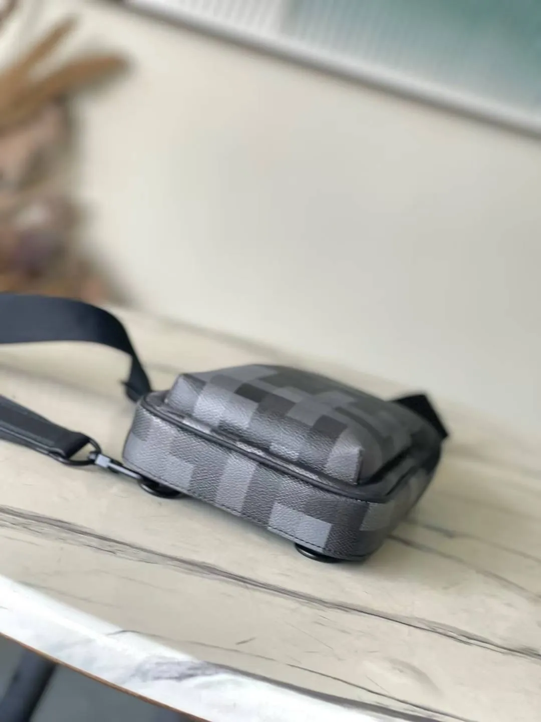 💰900 Top Original M14953 Damoflage black coated canvas adds a contemporary feel to the Avenue Slingbag's modern silhouette. A pixelated checkerboard pattern of grays and blacks is paired with matte black hardware for a masculine look. The Avenue features a main compartment and two zippered pockets for added functionality. The single shoulder strap is adjustable for comfortable cross-body wear. Appearance may vary slightly depending on pattern placement. Size: 16*5.7*33cm