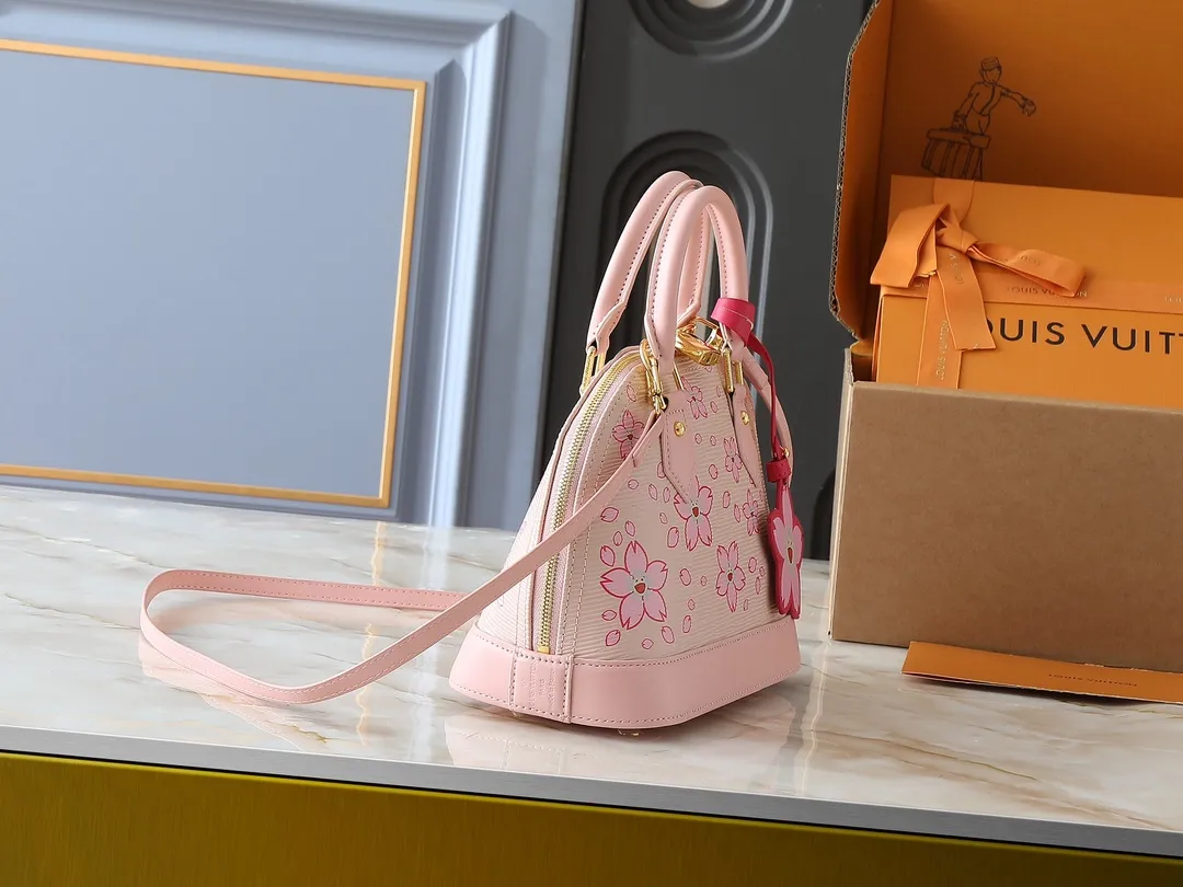 💰240💰Upgraded Original M13104 M53152 [LV × TM Alma BB Handbag] Sakura (Takashi Murakami) Created by Japanese artist Takashi Murakami, Maison’s brightly colored icon bag "LV × TM ALMA BB" is updated with a cheerful cherry blossom pattern that symbolizes regeneration. St adds gold hardware to Epi leather in soft pink tones to create a refined impression. You can enjoy various holding styles with the Tron handle and detachable leather strap. The interior can store daily items including large smartphones. Dimensions: 23.5 x 17.5 x 11.5 cm