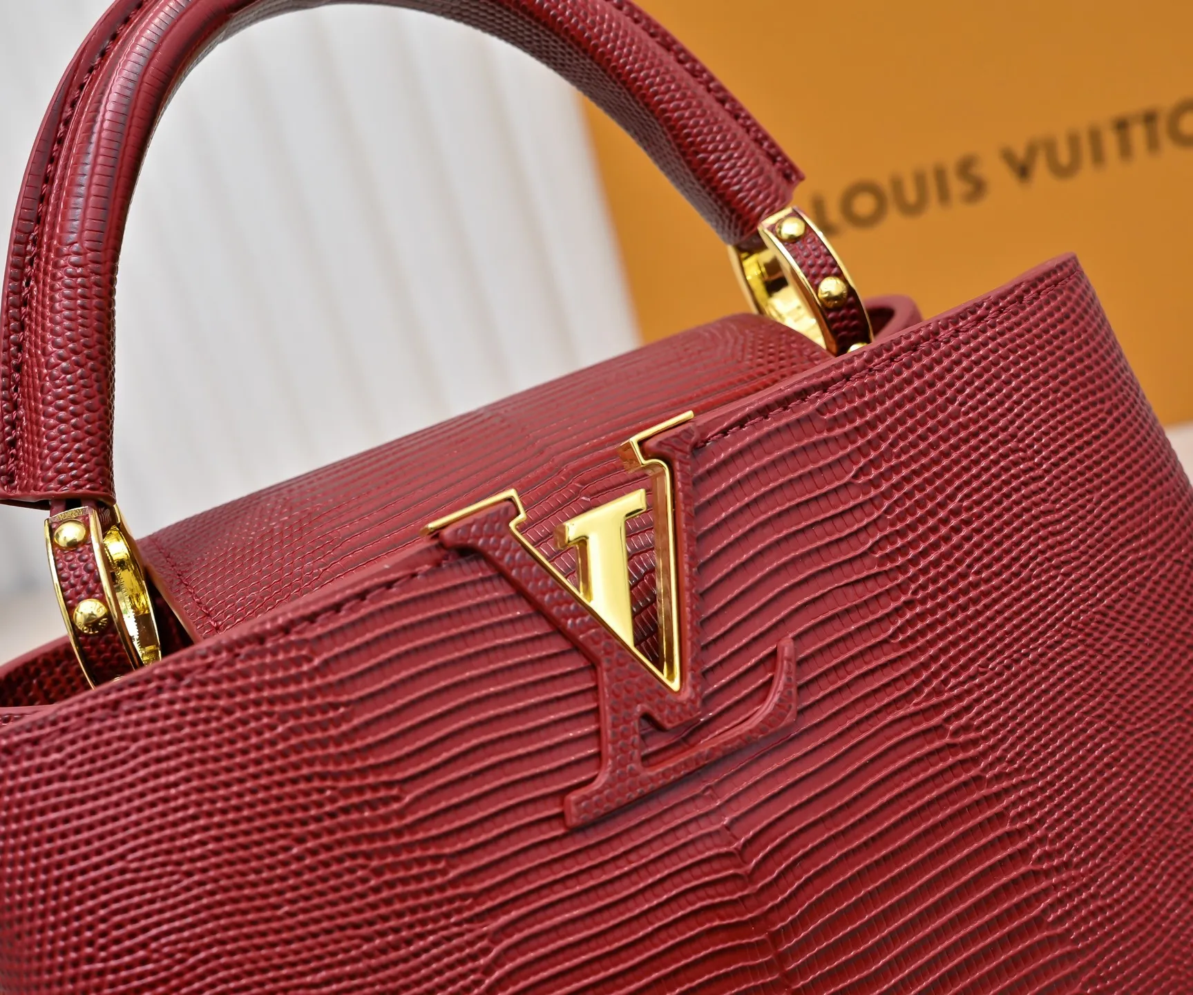 Top-quality original P420 Guangzhou-made M99528 maroon lizard skin gold buckle CapucinesBB handbag exquisitely combines graceful lizard skin outer layer, delicate sheepskin lining and luster metal parts. The iconic flap makes two styles fashionable. The LV logo can be read on the inside and Monogram flowers bloom on the outside. It can light up an eye-catching corner for evening occasions and add a personalized atmosphere to the wardrobe. Shine gorgeous style in day and night occasions.  Detailed features 27 x 18 x 9 cm (length x height x width)