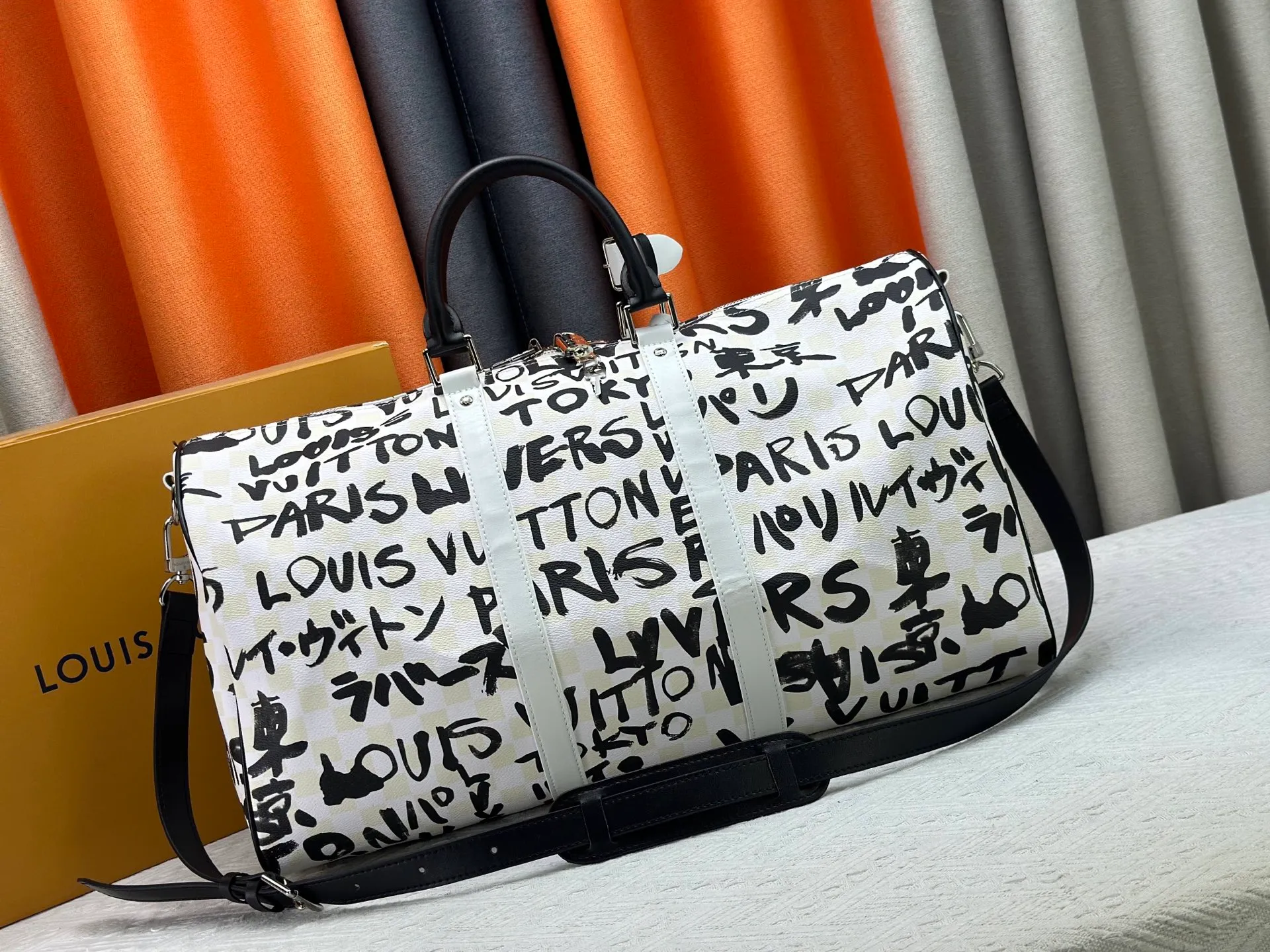 P420 Guangzhou goods N40804 M41416 Tokyo 1 style Keepall Bandoulière 50 travel bag is jointly created by Japanese designers Nigo and Pharrell Williams. It is laid out with elegant plaid on the cow leather, and then writes eye-catching words in French and Japanese. A cotton lining pattern bears witness to Nigo's artistic vision, and a removable LV Dynasty nameplate highlights the brand's identity. 29 cm