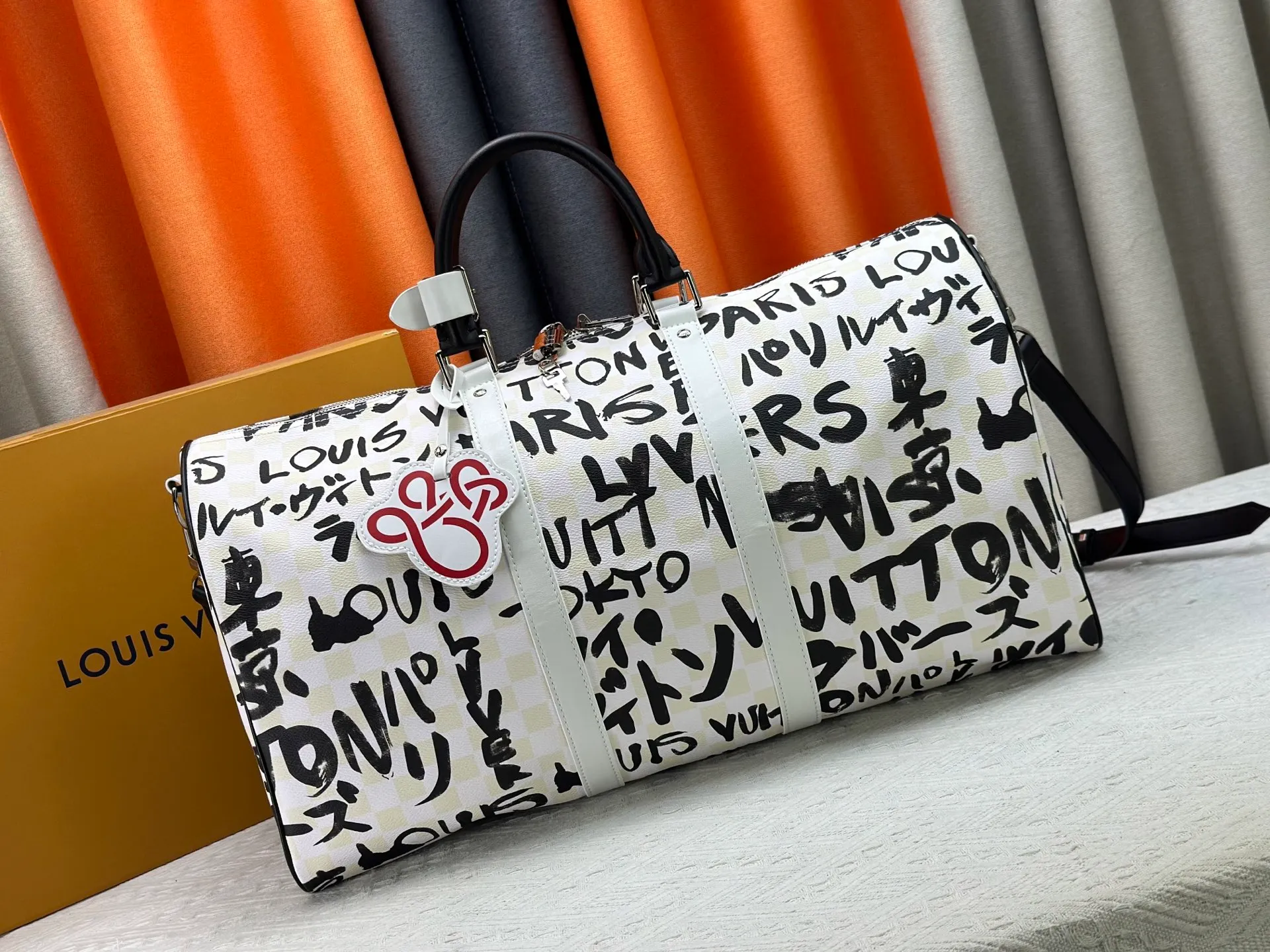 P420 Guangzhou goods N40804 M41416 Tokyo 1 style Keepall Bandoulière 50 travel bag is jointly created by Japanese designers Nigo and Pharrell Williams. It is laid out with elegant plaid on the cow leather, and then writes eye-catching words in French and Japanese. A cotton lining pattern bears witness to Nigo's artistic vision, and a removable LV Dynasty nameplate highlights the brand's identity. 29 cm