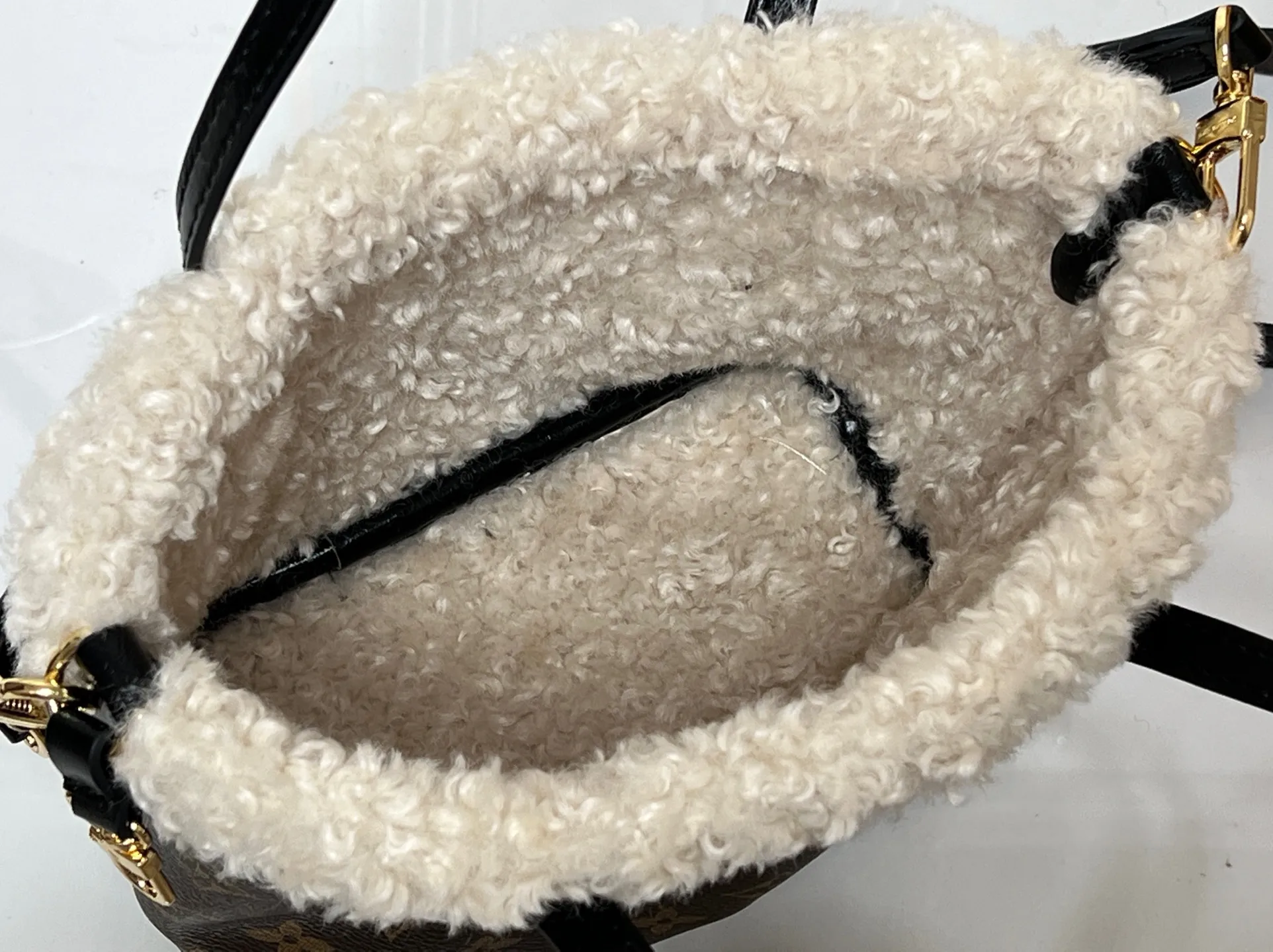 Batch 360💰M26315 12099 Guangzhou goods upgraded version This Neverfull Bandoulière Inside Out BB handbag comes from the LV Ski series and is made of Monogram canvas with trendy shearling trim and lining. The Teddygram logo is laid out on it, creating a sophisticated style with dazzling metal parts. A zippered pocket adds a finishing touch to the reversible design, allowing it to be held individually. Long shoulder straps allow for cross-body comfort. 16.5 x 11 x 26.5 cm (height x width x length)