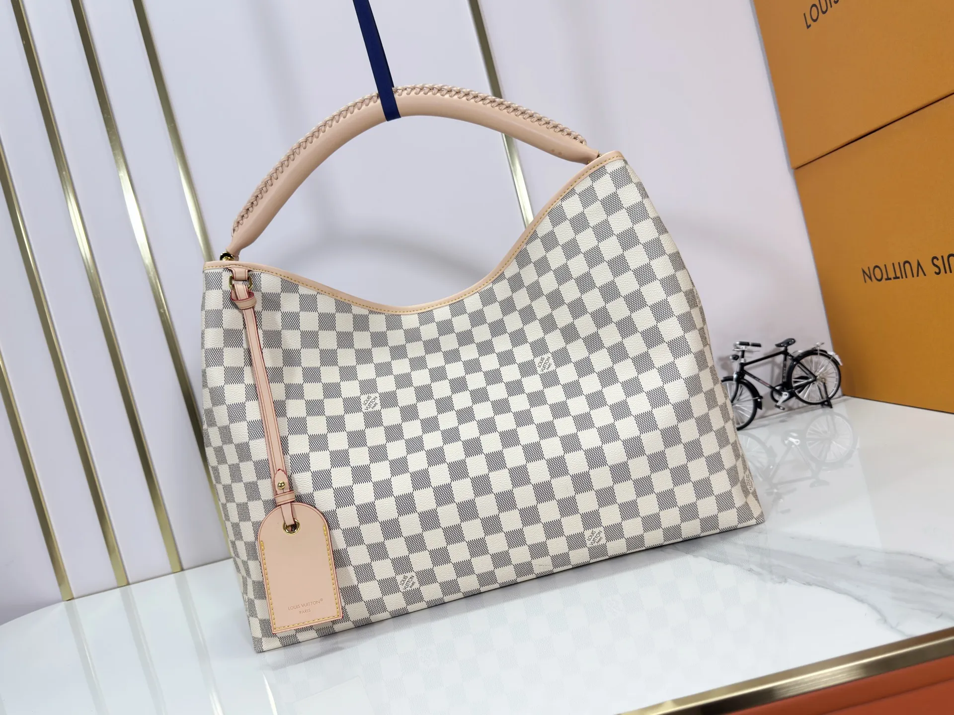 P280 upgrades the original M25877 Again handbag, a new interpretation of the iconic Artsy design first launched in 2010, now more flexible, more iconic and more refined. Rooted in LV’s DNA, this bag pays homage to Louis Vuitton’s craftsmanship with its classic Monogram canvas base, hand-woven handles and customizable name tag. It's spacious enough to hold a laptop and opens to reveal multiple pockets. Gold hooks can be used to hang playful accessories! ! Size:50x30x15.5CM