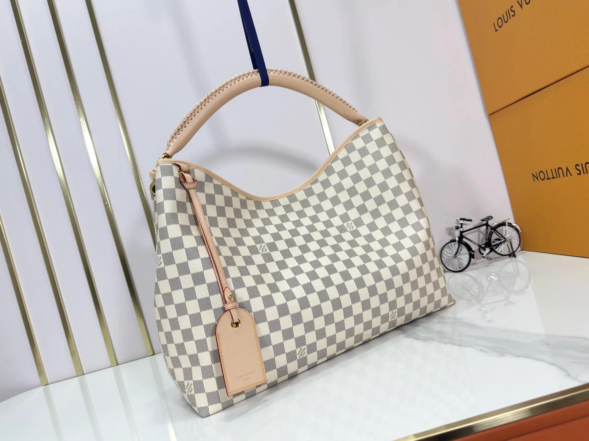 P280 upgrades the original M25877 Again handbag, a new interpretation of the iconic Artsy design first launched in 2010, now more flexible, more iconic and more refined. Rooted in LV’s DNA, this bag pays homage to Louis Vuitton’s craftsmanship with its classic Monogram canvas base, hand-woven handles and customizable name tag. It's spacious enough to hold a laptop and opens to reveal multiple pockets. Gold hooks can be used to hang playful accessories! ! Size:50x30x15.5CM