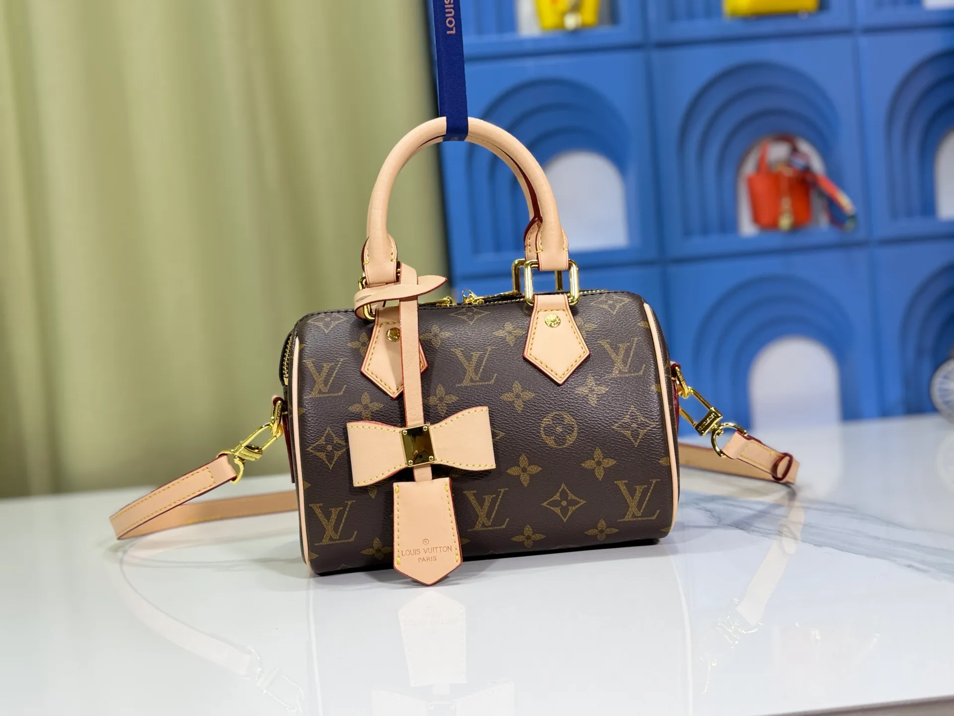 P260 Upgraded from the original version, this M46234 M46222 Speedy Bandoulière 20 handbag is made of soft coated canvas, with the full-length Monogram pattern traced in colorful rainbow tones, highlighting the smart style of the Louis Vuitton x Murakami reissue series. The Toron handle and detachable shoulder strap are constructed of cow leather, the metal corners recall classic luggage elements, and the bow-shaped key bag and padlock add brand touches. Dimensions: 20.5 x 13.5 x 12.0 cm (length x height x width)