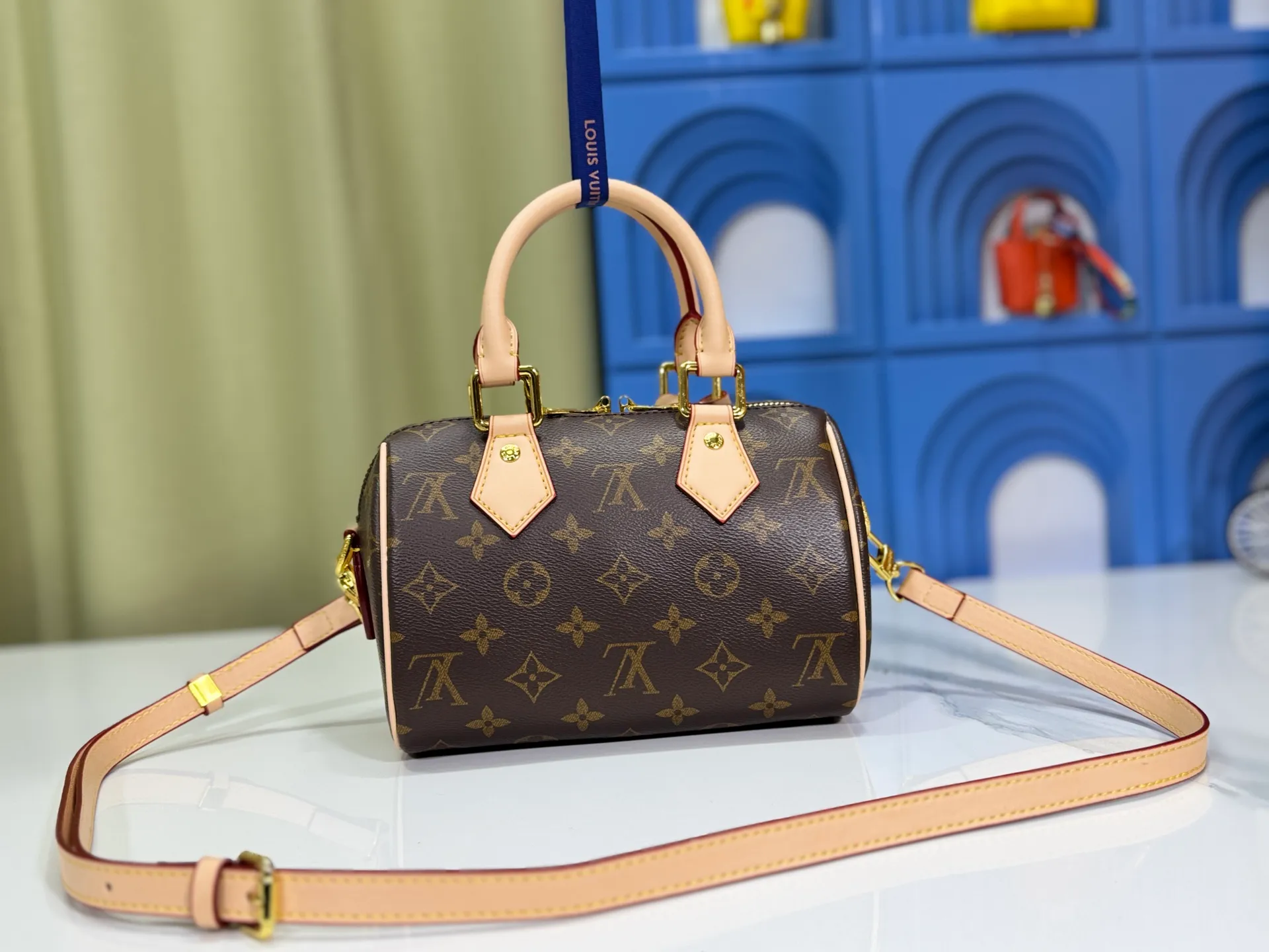 P260 Upgraded from the original version, this M46234 M46222 Speedy Bandoulière 20 handbag is made of soft coated canvas, with the full-length Monogram pattern traced in colorful rainbow tones, highlighting the smart style of the Louis Vuitton x Murakami reissue series. The Toron handle and detachable shoulder strap are constructed of cow leather, the metal corners recall classic luggage elements, and the bow-shaped key bag and padlock add brand touches. Dimensions: 20.5 x 13.5 x 12.0 cm (length x height x width)