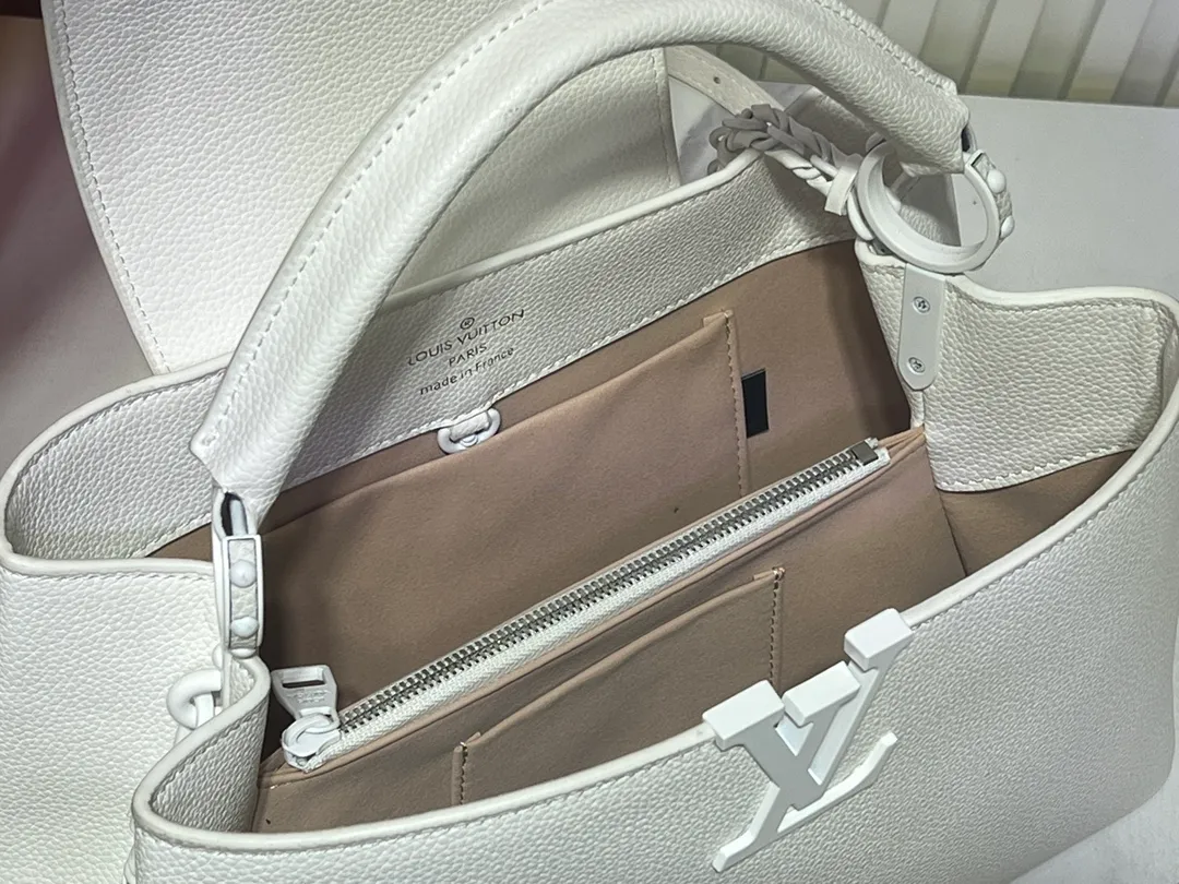Batch 380💰M24880 M24607 Black Out series launches the Capucines Souple large handbag, an enlarged version of the classic design made of matte Taurillon leather and elegant metal parts, with the iconic LV letters. The neat interior has multiple pockets to easily hold A4-size documents. 38.0 x 23.0 x 16.0 cm (Length x Height x Width) • Matt Taurillon cow leather • Cow leather trim • Cow leather lining • Matt metal hardware • Flap can be placed on the inside or outside • Internal compartment • Internal zip pocket • Internal patch pocket • Metal base stud • Shoulder strap: removable, adjustable • Half-length strap: 36.0 cm • Half-length adjustable strap: 59.0 cm • Handle: Single handle