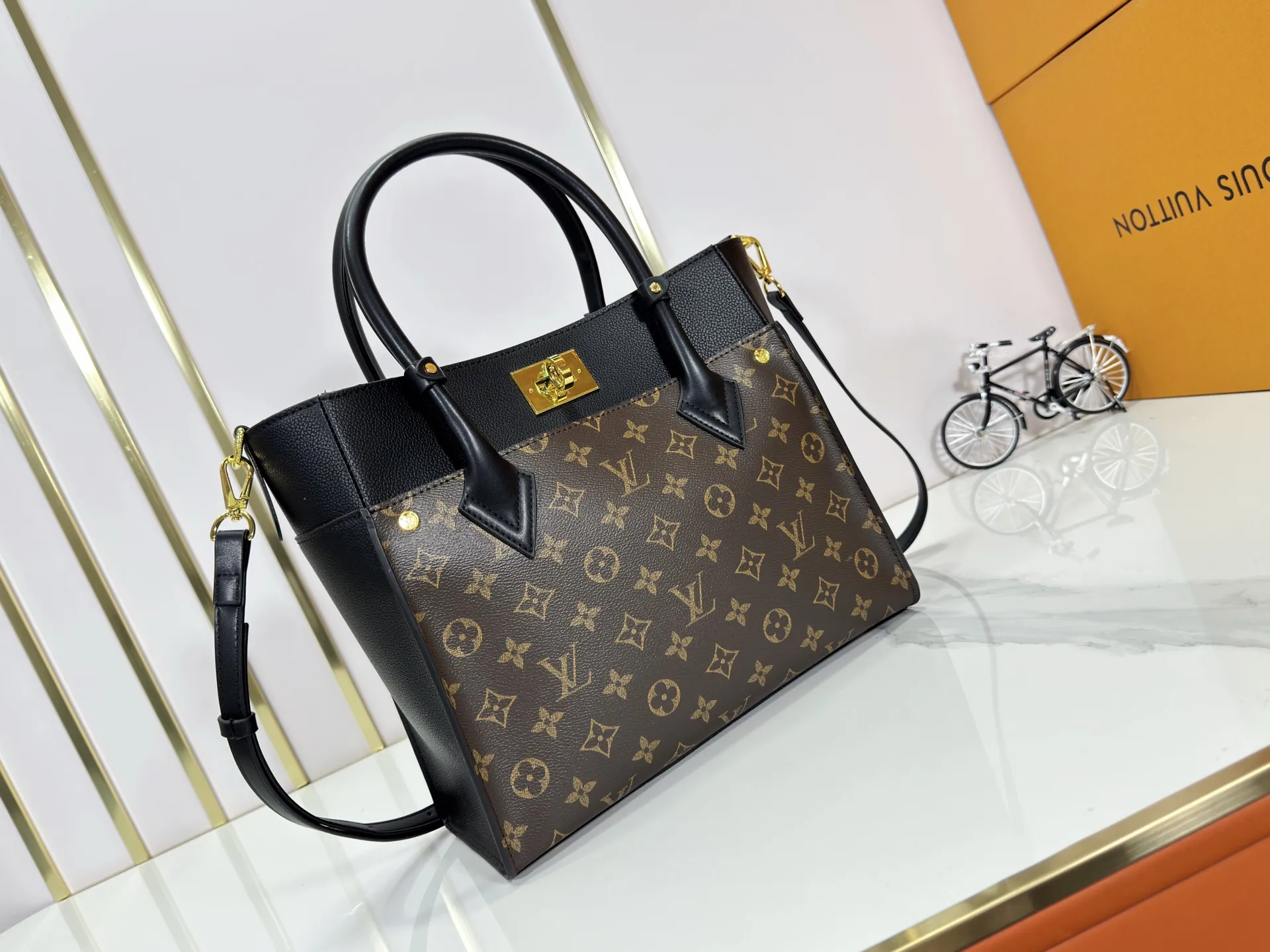 P340 upgraded original M53826 M53825 M53824 M53823On My Side handbag shows the elegant fusion of calfskin and classic Monogram canvas. Contrasting canvas shapes the large outer pocket, creating a trompe l'oeil effect as if two handbags merge into one. Plenty of space can easily accommodate office needs, and the adjustable shoulder strap allows for a cross-body style. Dimensions: 30.5 x 24.5 x 14 cm (Length x Height x Width) - Calfskin and Monogram coated canvas - Cowhide leather trim - Microfiber lining - 2 top handles for hand or elbow carry - Adjustable shoulder strap for shoulder or cross-body wear - Lock closure - 2 outer pockets with magnetic closure - Zip pocket - 1 patch pocket