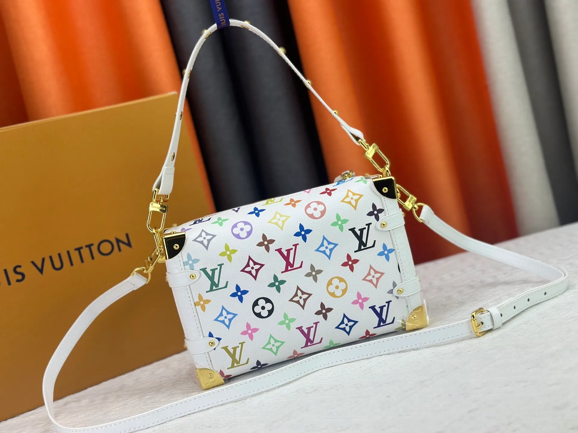 P280 M14046 M46358 Black Tricolor White Tricolor This Side Trunk medium handbag uses a humorous Monogram pattern to express the smart style of the Louis Vuitton × Murakami reissue series. It is made of soft cow leather with reinforced metal corners and the iconic S-lock lock, which can easily accommodate daily needs. The square shape is a nod to the brand's classic luggage, and the removable studded handle and shoulder strap allow for flexible carrying. Size: 23.5x16x8.5cm