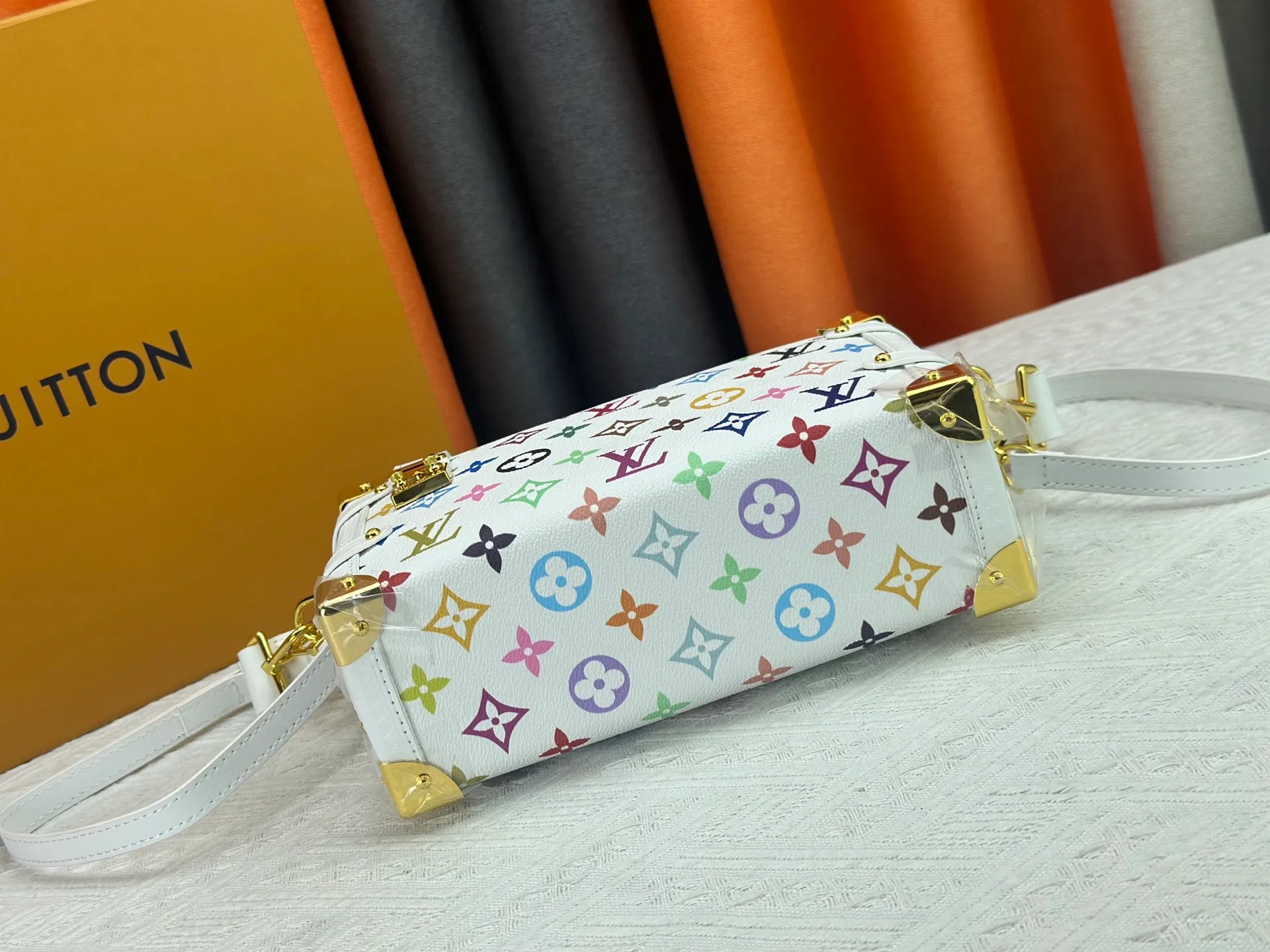 P280 M14046 M46358 Black Tricolor White Tricolor This Side Trunk medium handbag uses a humorous Monogram pattern to express the smart style of the Louis Vuitton × Murakami reissue series. It is made of soft cow leather with reinforced metal corners and the iconic S-lock lock, which can easily accommodate daily needs. The square shape is a nod to the brand's classic luggage, and the removable studded handle and shoulder strap allow for flexible carrying. Size: 23.5x16x8.5cm