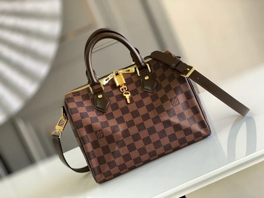 💰760 Top original order N41368 SPEEDY 25 handbag (with shoulder strap) The Speedy 25 handbag made of iconic Damier Ebène canvas shows the classic Louis Vuitton charm. Whether this bag is carried by hand, carried on the shoulder or cross-body, the user exudes endless elegance. Detailed Features 25 x 19 x 15 cm (Length x Height x Width) Smooth leather trim Shiny gold-tone brass hardware Double zip closure with padlock Internal pocket D-ring for keys and accessories Soft fabric lining Shoulder strap: Removable, adjustable Strap half-length: 46.5 cm Strap half-length adjustable to: 55.0 cm Handle: Double handle