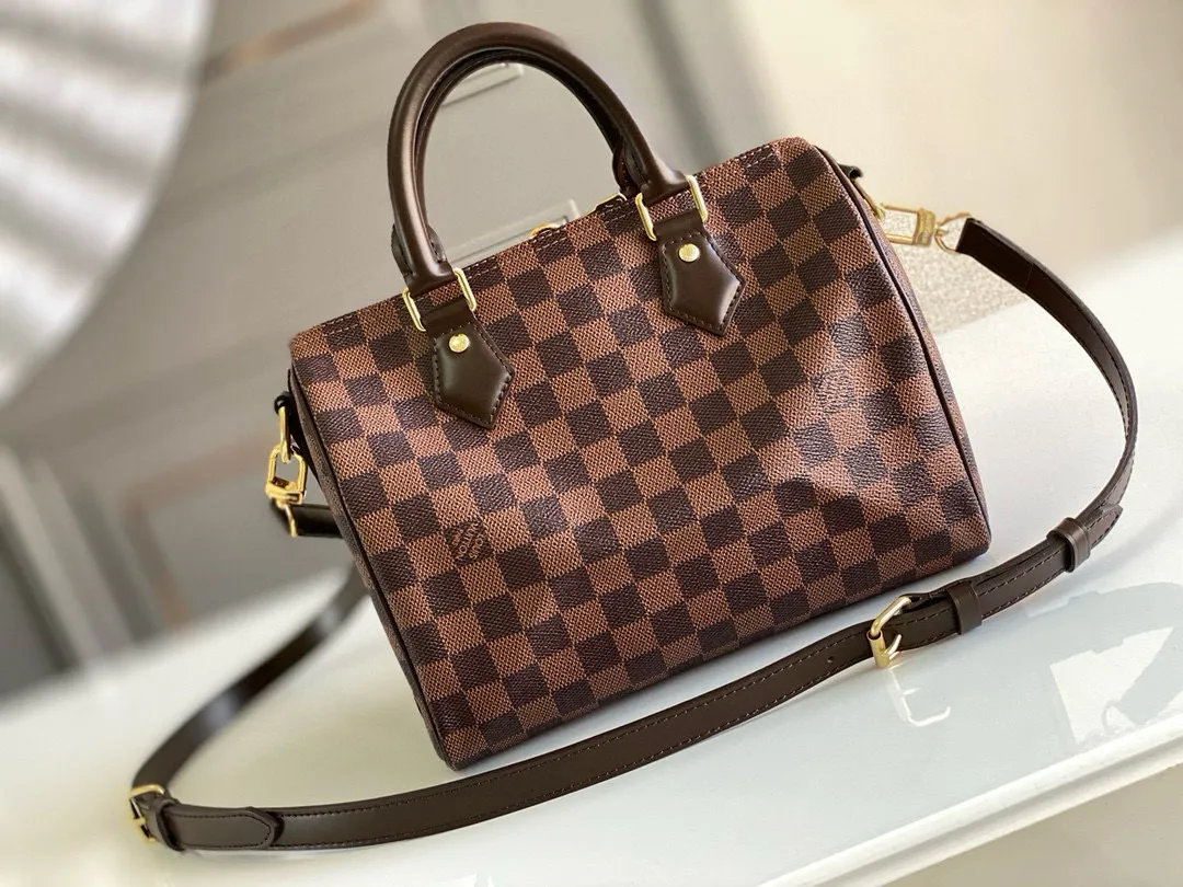 💰760 Top original order N41368 SPEEDY 25 handbag (with shoulder strap) The Speedy 25 handbag made of iconic Damier Ebène canvas shows the classic Louis Vuitton charm. Whether this bag is carried by hand, carried on the shoulder or cross-body, the user exudes endless elegance. Detailed Features 25 x 19 x 15 cm (Length x Height x Width) Smooth leather trim Shiny gold-tone brass hardware Double zip closure with padlock Internal pocket D-ring for keys and accessories Soft fabric lining Shoulder strap: Removable, adjustable Strap half-length: 46.5 cm Strap half-length adjustable to: 55.0 cm Handle: Double handle