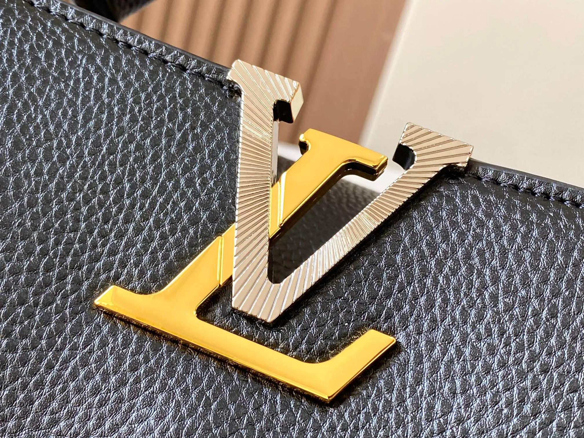 P500 [Guangzhou top quality original version] M26532 black gold. This modern version of Capucines BB is made of timeless Taurillon leather and equipped with a jewelry-inspired Infinity chain. The bag is decorated with double galvanized metal parts, including the iconic Monogram floral pattern, and the LV Initials logo created with sunburst technology, creating a sundial-like light and shadow effect. The bag has multiple pockets and a detachable shoulder strap, allowing it to be carried on one shoulder or across the body. 27 x 17.3 x 9 (cm) (length x height x width)