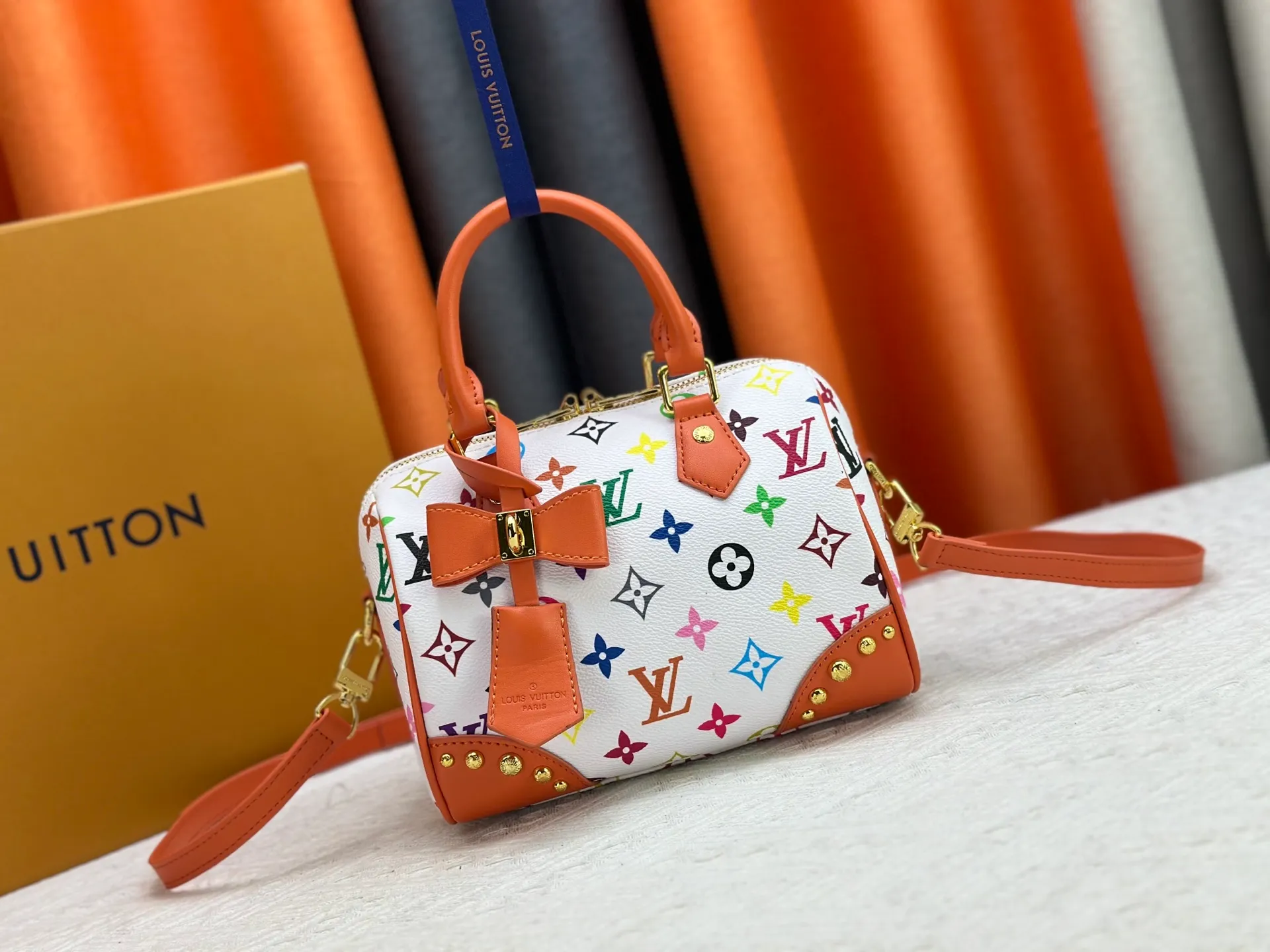 P260 upgraded original M58953 M46234 M46222 Speedy Bandoulière 20 handbag is made of soft coated canvas, and the full-length Monogram pattern is traced in colorful rainbow tones, highlighting the smart style of the Louis Vuitton x Murakami reissue series. The Toron handle and detachable shoulder strap are constructed of cow leather, the metal corners recall classic luggage elements, and the bow-shaped key bag and padlock add brand touches. Dimensions: 20.5 x 13.5 x 12.0 cm (length x height x width)