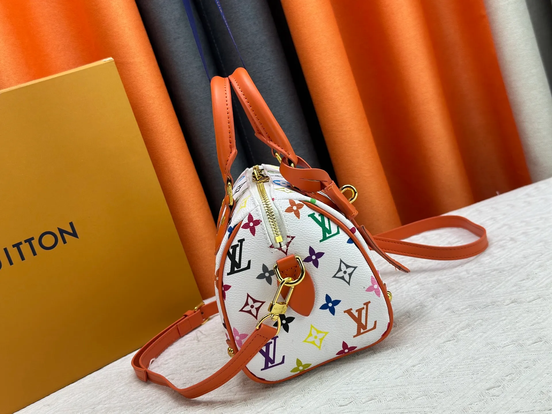 P260 upgraded original M58953 M46234 M46222 Speedy Bandoulière 20 handbag is made of soft coated canvas, and the full-length Monogram pattern is traced in colorful rainbow tones, highlighting the smart style of the Louis Vuitton x Murakami reissue series. The Toron handle and detachable shoulder strap are constructed of cow leather, the metal corners recall classic luggage elements, and the bow-shaped key bag and padlock add brand touches. Dimensions: 20.5 x 13.5 x 12.0 cm (length x height x width)