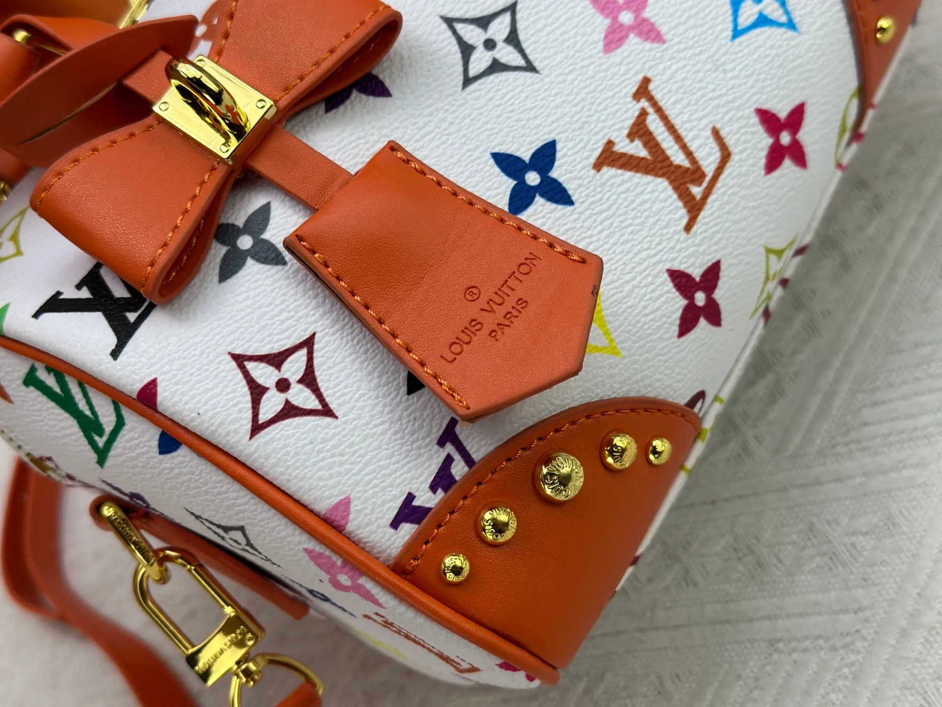 P260 upgraded original M58953 M46234 M46222 Speedy Bandoulière 20 handbag is made of soft coated canvas, and the full-length Monogram pattern is traced in colorful rainbow tones, highlighting the smart style of the Louis Vuitton x Murakami reissue series. The Toron handle and detachable shoulder strap are constructed of cow leather, the metal corners recall classic luggage elements, and the bow-shaped key bag and padlock add brand touches. Dimensions: 20.5 x 13.5 x 12.0 cm (length x height x width)
