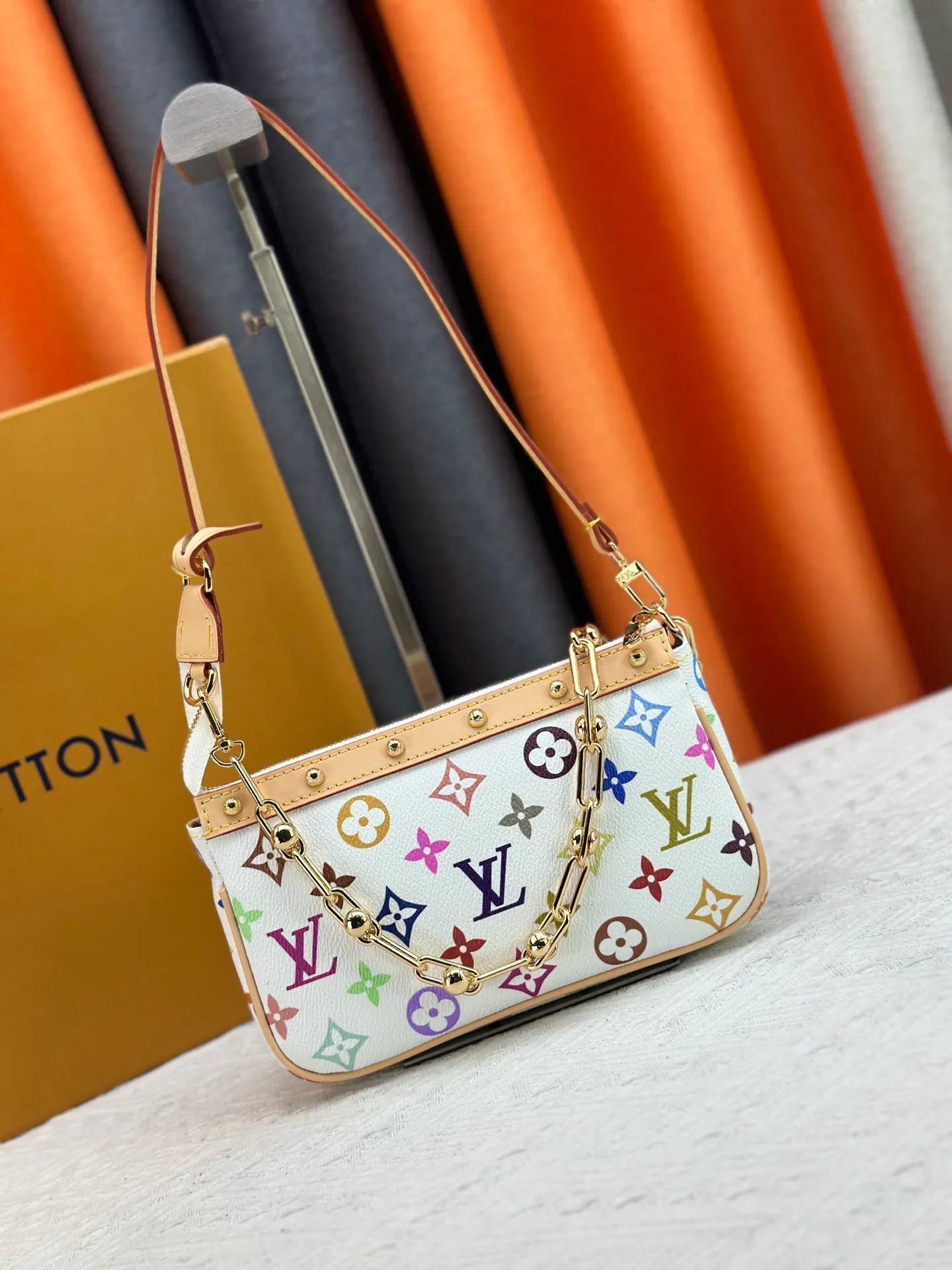 P220 M13404 M13663 Black color White color This Pochette Accessoires handbag is made of coated canvas, with colorful Monogram patterns to interpret the smart style of the Louis Vuitton × Murakami cross-border collaboration series. Calf leather trim and dazzling hardware add to the sophisticated details, while the detachable shoulder strap and chain provide flexible carry. Size: 22x13x4cm
