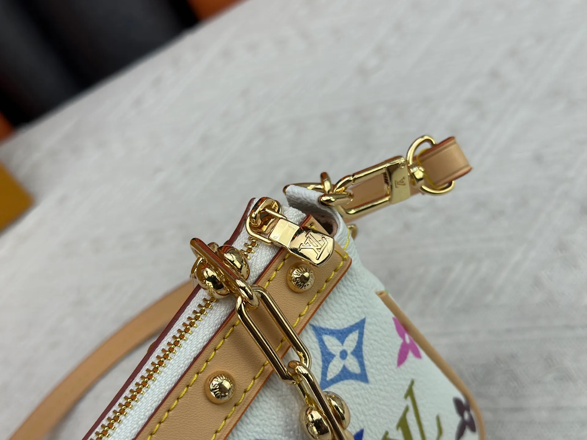 P220 M13404 M13663 Black color White color This Pochette Accessoires handbag is made of coated canvas, with colorful Monogram patterns to interpret the smart style of the Louis Vuitton × Murakami cross-border collaboration series. Calf leather trim and dazzling hardware add to the sophisticated details, while the detachable shoulder strap and chain provide flexible carry. Size: 22x13x4cm