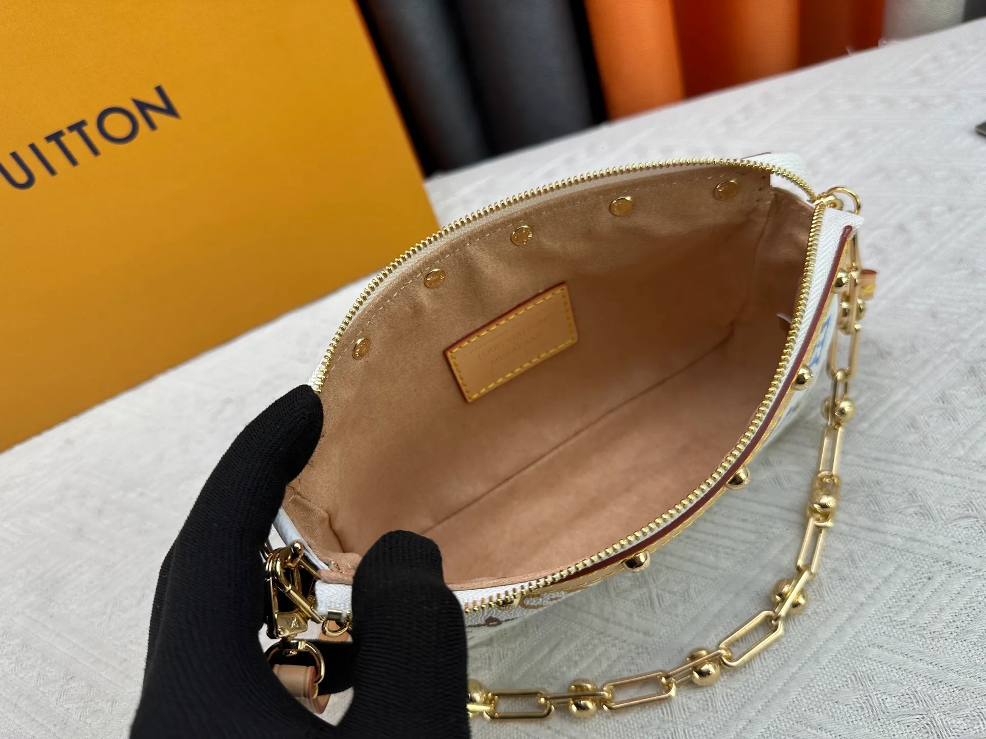 P220 M13404 M13663 Black color White color This Pochette Accessoires handbag is made of coated canvas, with colorful Monogram patterns to interpret the smart style of the Louis Vuitton × Murakami cross-border collaboration series. Calf leather trim and dazzling hardware add to the sophisticated details, while the detachable shoulder strap and chain provide flexible carry. Size: 22x13x4cm