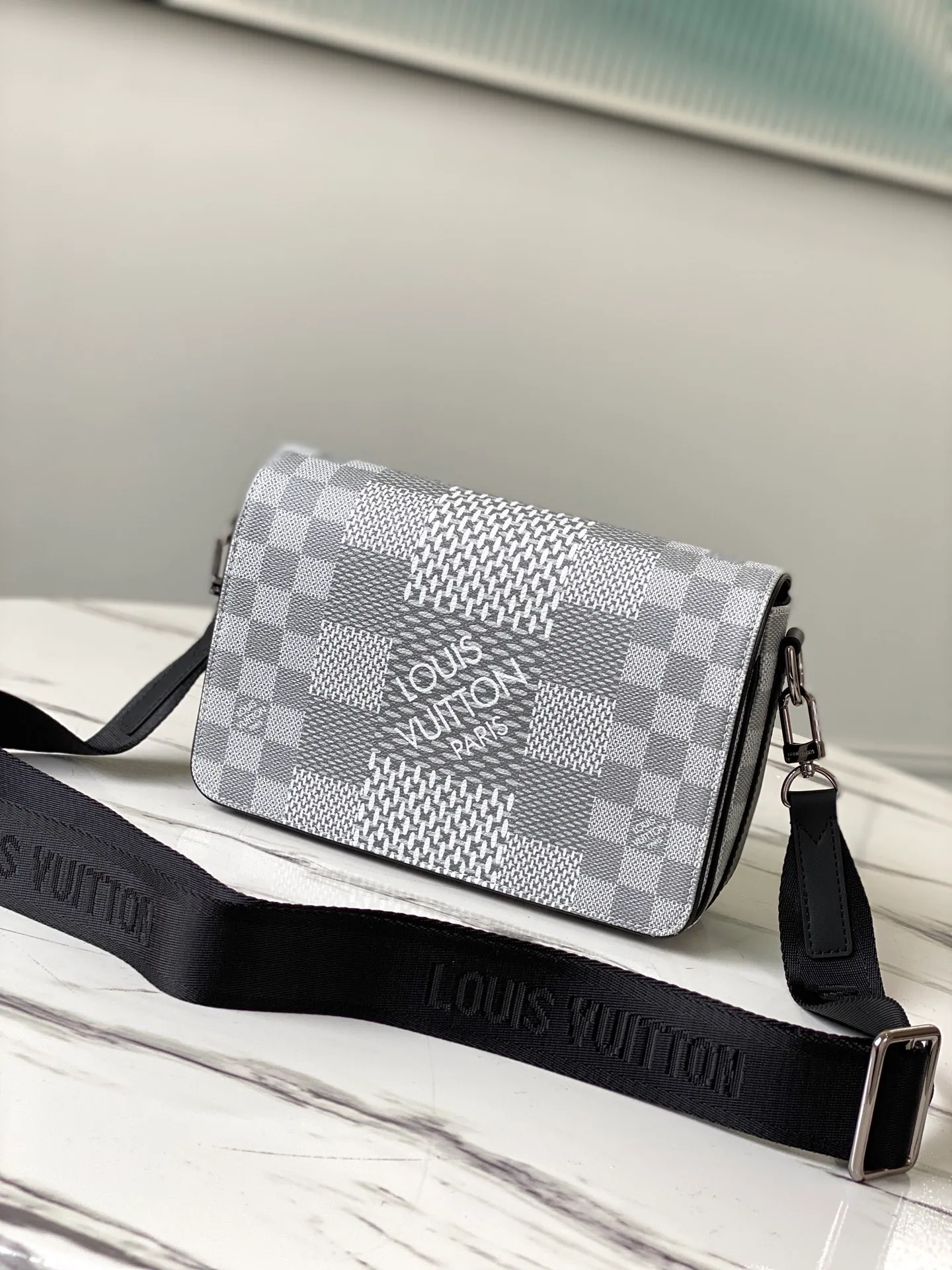 💰840 Top Original N50014 Silver White This Studio messenger bag is made of Damier Graphite 3D canvas, telling the modern renewal of the brand's legendary plaid. The neat structure includes ample functional space, and the detachable shoulder strap is subtly embellished with the brand logo, defining a trendy new way to store travel items. Dimensions: 23.5 x 14 x 5 cm