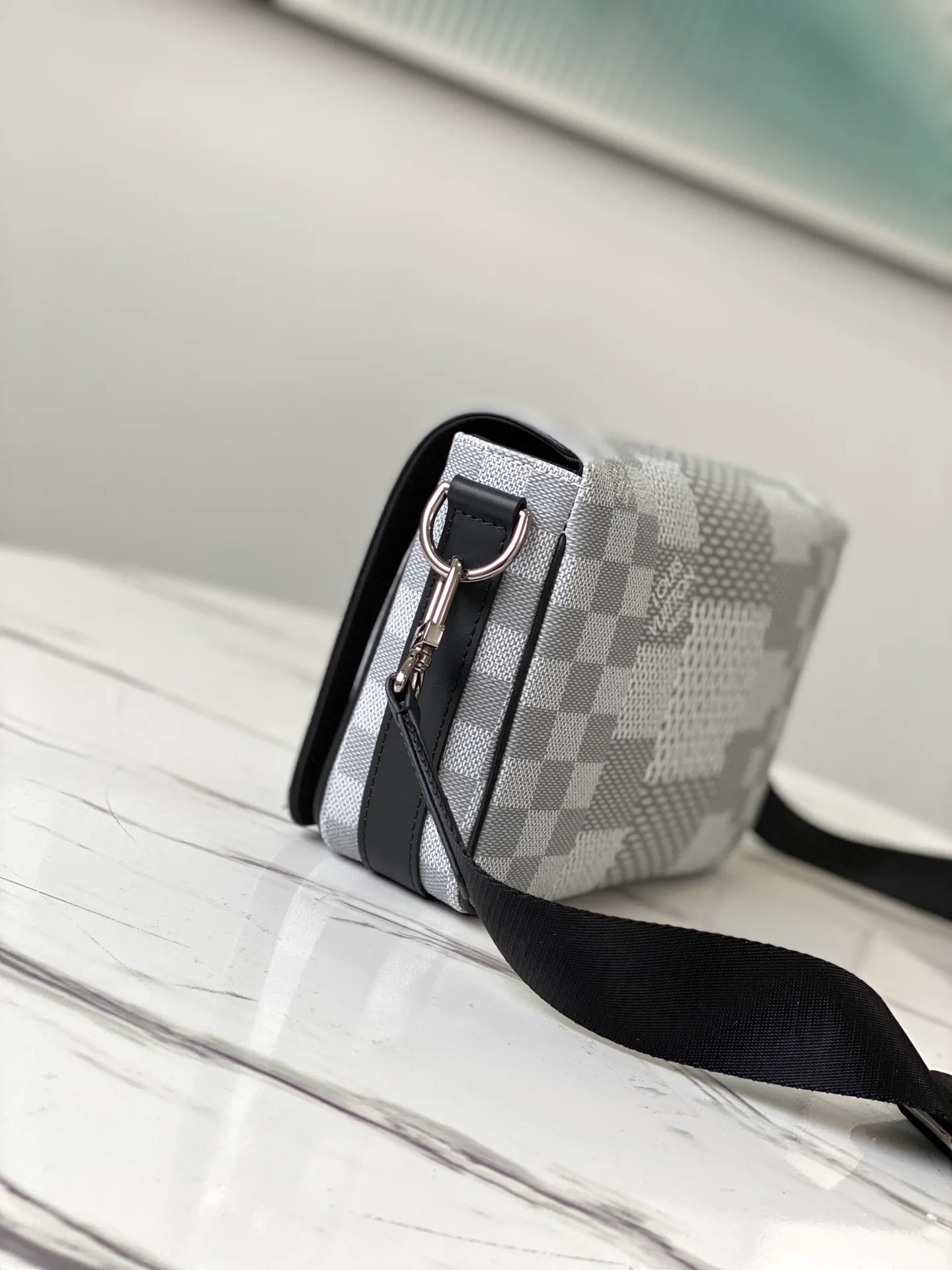 💰840 Top Original N50014 Silver White This Studio messenger bag is made of Damier Graphite 3D canvas, telling the modern renewal of the brand's legendary plaid. The neat structure includes ample functional space, and the detachable shoulder strap is subtly embellished with the brand logo, defining a trendy new way to store travel items. Dimensions: 23.5 x 14 x 5 cm