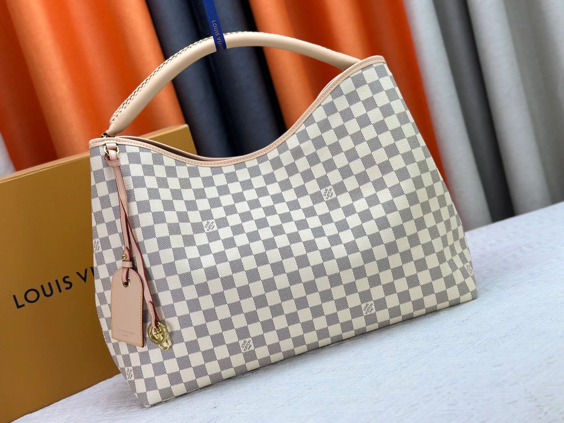 P300 upgrades the original M25877 Again bag, a new interpretation of the iconic Artsy design first launched in 2010, now more flexible, more iconic and more refined. Rooted in LV’s DNA, this bag pays homage to Louis Vuitton’s craftsmanship with its classic Monogram canvas base, hand-woven handles and customizable name tag. It's spacious enough to hold a laptop and opens to reveal multiple pockets. Gold hooks can be used to hang playful accessories! ! Size:50x30x15.5CM