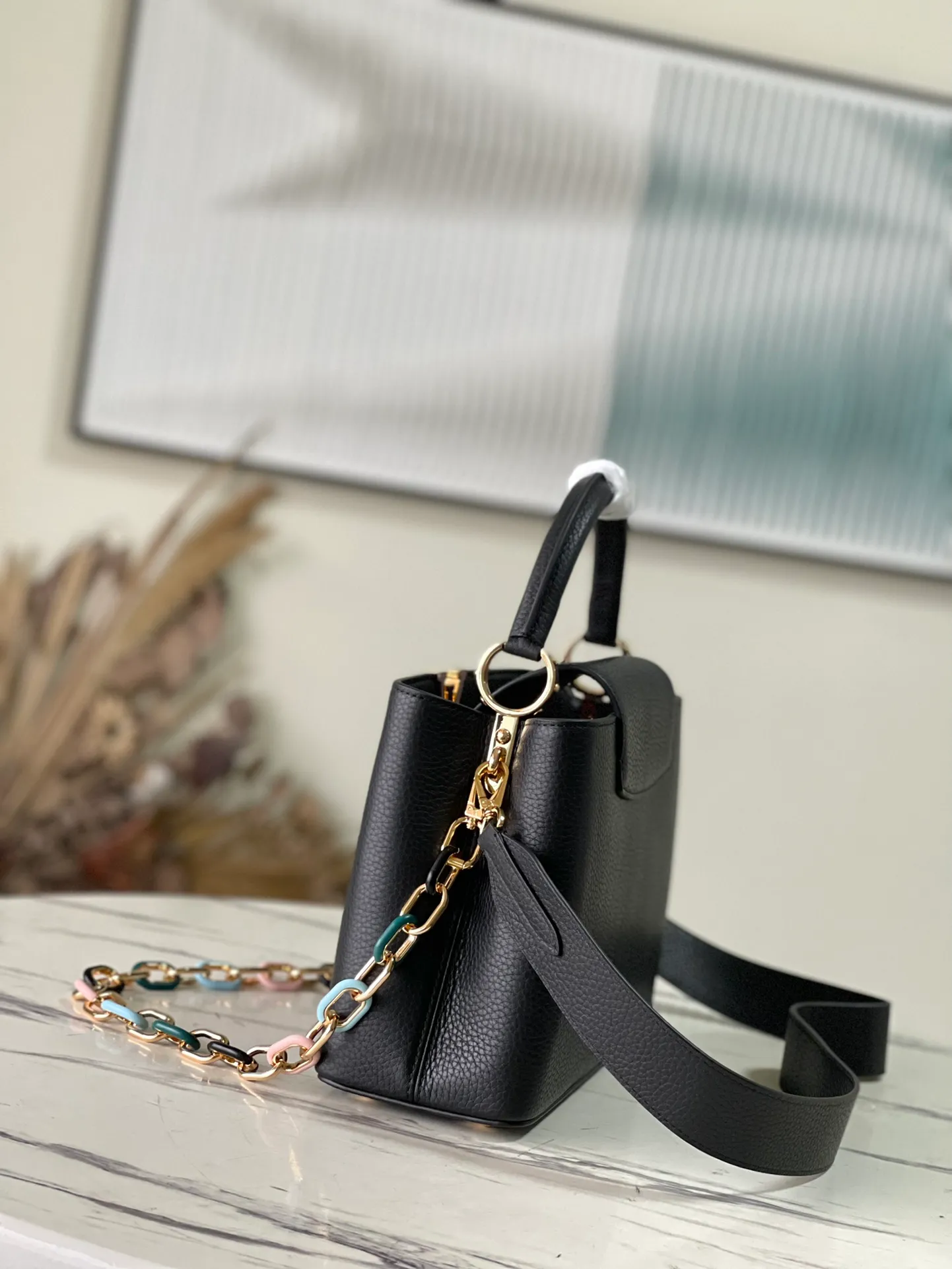 💰2760 (Special Grade Original Leather) M21641 Black Medium This Capucines medium handbag is made of Taurillon leather, with metal and resin links interlocking with each other, adding a fun carrying method in addition to the top handle and detachable wide shoulder strap. The signature flap of the Capucines collection is tucked in to reveal the logo. Dimensions: 31.5 x 20 x 11 cm