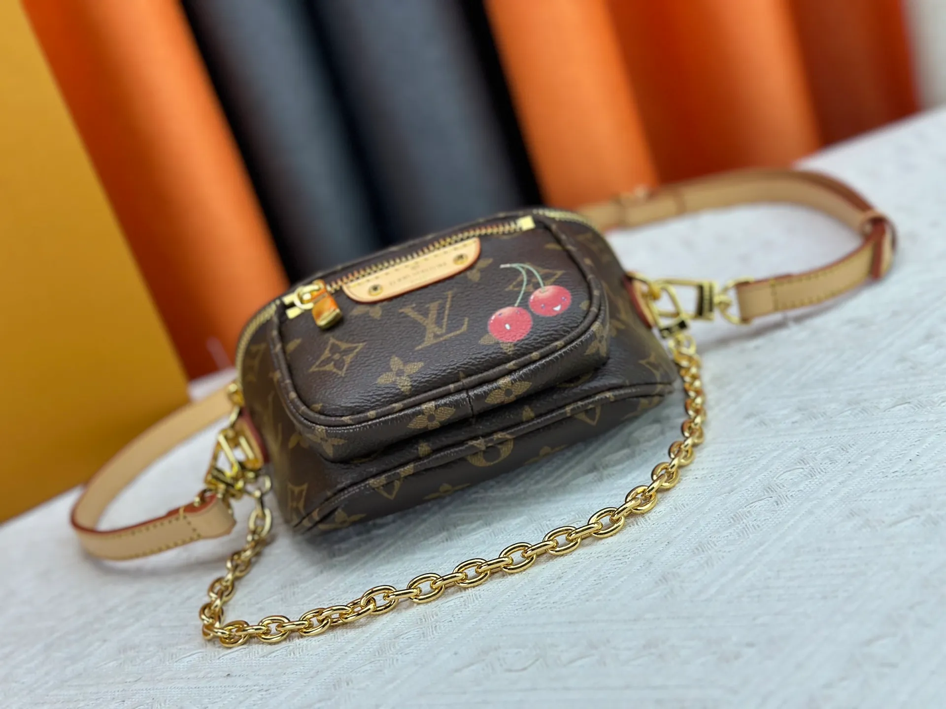 P240 M82208 M00130 M82335 This Mini Bumbag handbag comes from the LV Gradient series. The Monogram embossing of Monogram Empreinte leather renders the gradient midsummer color. The on-trend construction features a zipped main compartment and a front pocket with a Louis Vuitton leather label. With the detachable chain and detachable and adjustable shoulder strap, it can be worn as a shoulder or cross-body bag. Dimensions: 17x12x9.5 cm