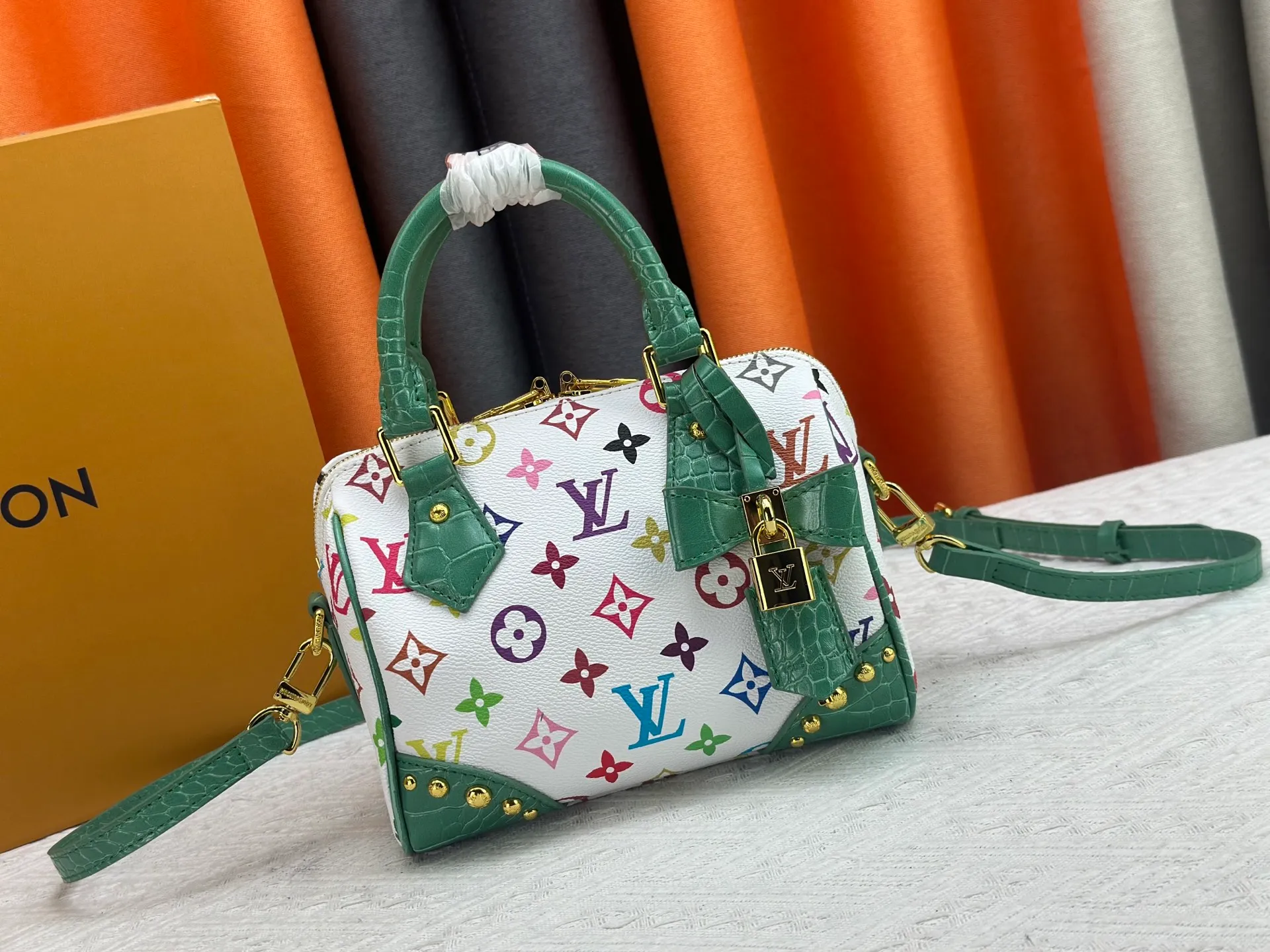 P260 Upgraded original crocodile pattern M13365 M58953 M46234 M46222 Speedy Bandoulière 20 handbag is made of soft coated canvas, and the full-length Monogram pattern is traced in colorful rainbow tones, highlighting the smart style of the Louis Vuitton x Murakami reissue series. The Toron handle and detachable shoulder strap are constructed of cow leather, the metal corners recall classic luggage elements, and the bow-shaped key bag and padlock add brand touches. Dimensions: 20.5 x 13.5 x 12.0 cm (length x height x width)