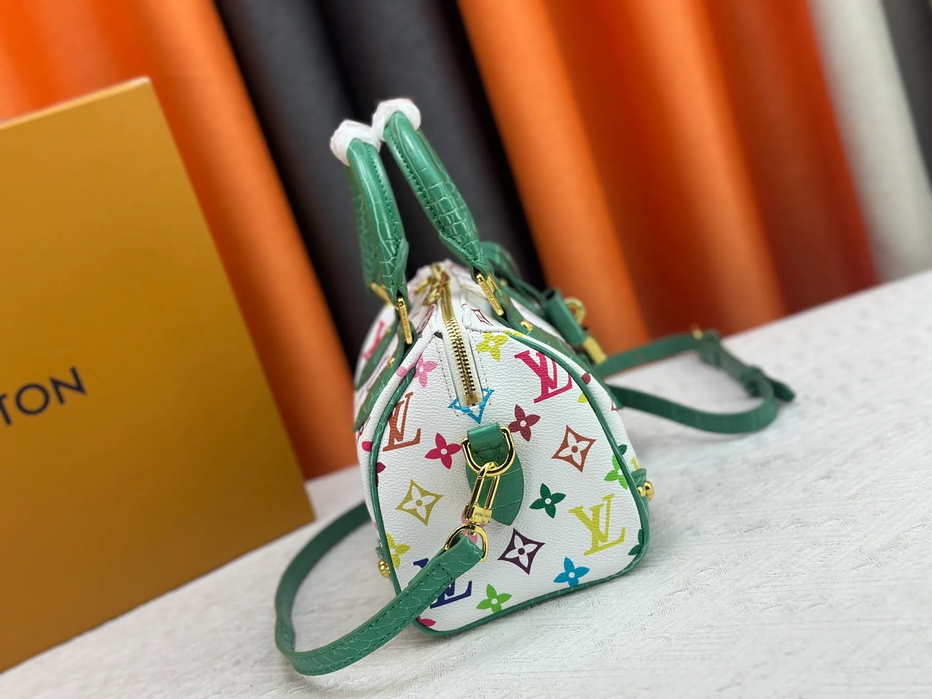 P260 Upgraded original crocodile pattern M13365 M58953 M46234 M46222 Speedy Bandoulière 20 handbag is made of soft coated canvas, and the full-length Monogram pattern is traced in colorful rainbow tones, highlighting the smart style of the Louis Vuitton x Murakami reissue series. The Toron handle and detachable shoulder strap are constructed of cow leather, the metal corners recall classic luggage elements, and the bow-shaped key bag and padlock add brand touches. Dimensions: 20.5 x 13.5 x 12.0 cm (length x height x width)