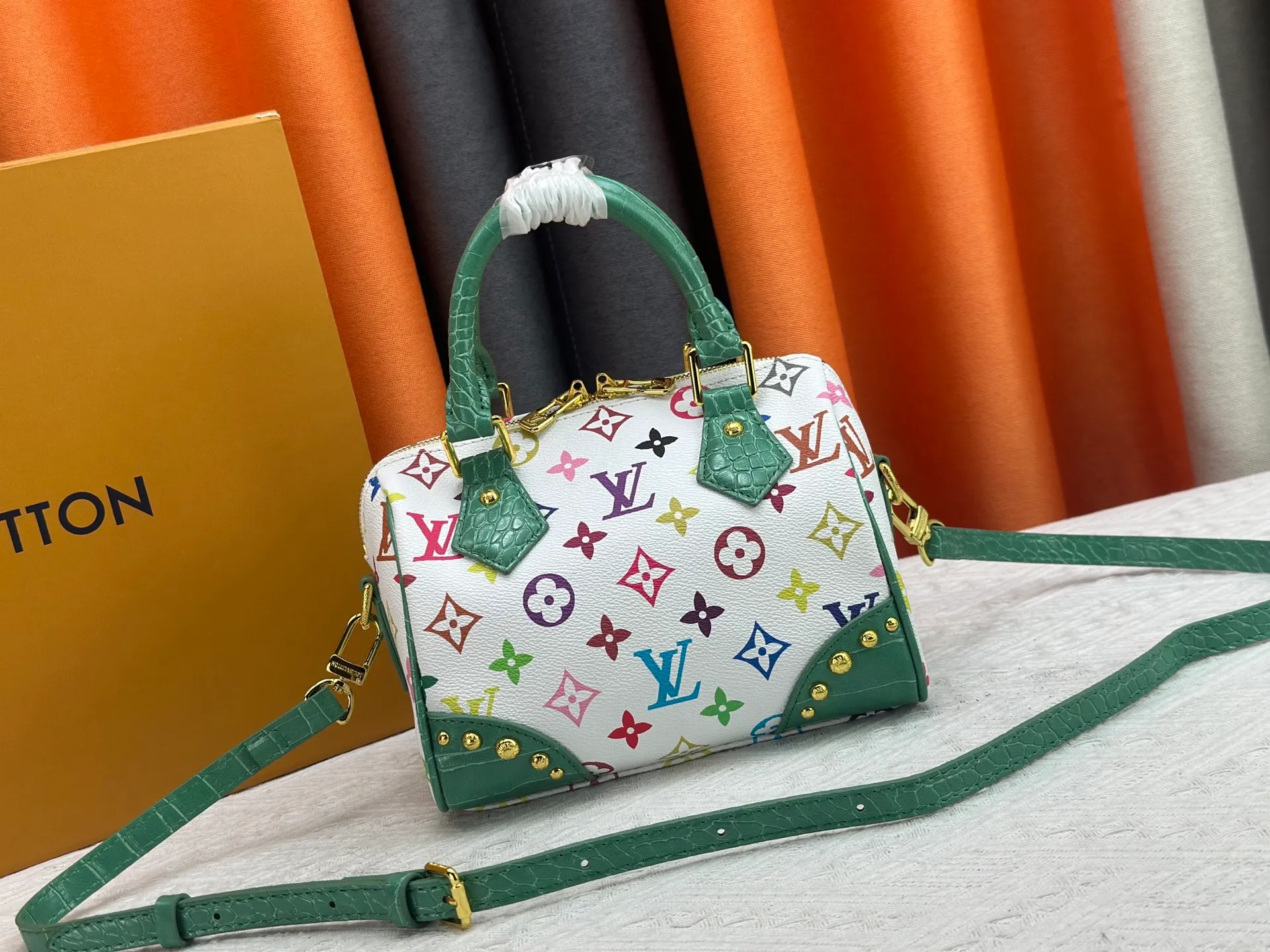 P260 Upgraded original crocodile pattern M13365 M58953 M46234 M46222 Speedy Bandoulière 20 handbag is made of soft coated canvas, and the full-length Monogram pattern is traced in colorful rainbow tones, highlighting the smart style of the Louis Vuitton x Murakami reissue series. The Toron handle and detachable shoulder strap are constructed of cow leather, the metal corners recall classic luggage elements, and the bow-shaped key bag and padlock add brand touches. Dimensions: 20.5 x 13.5 x 12.0 cm (length x height x width)