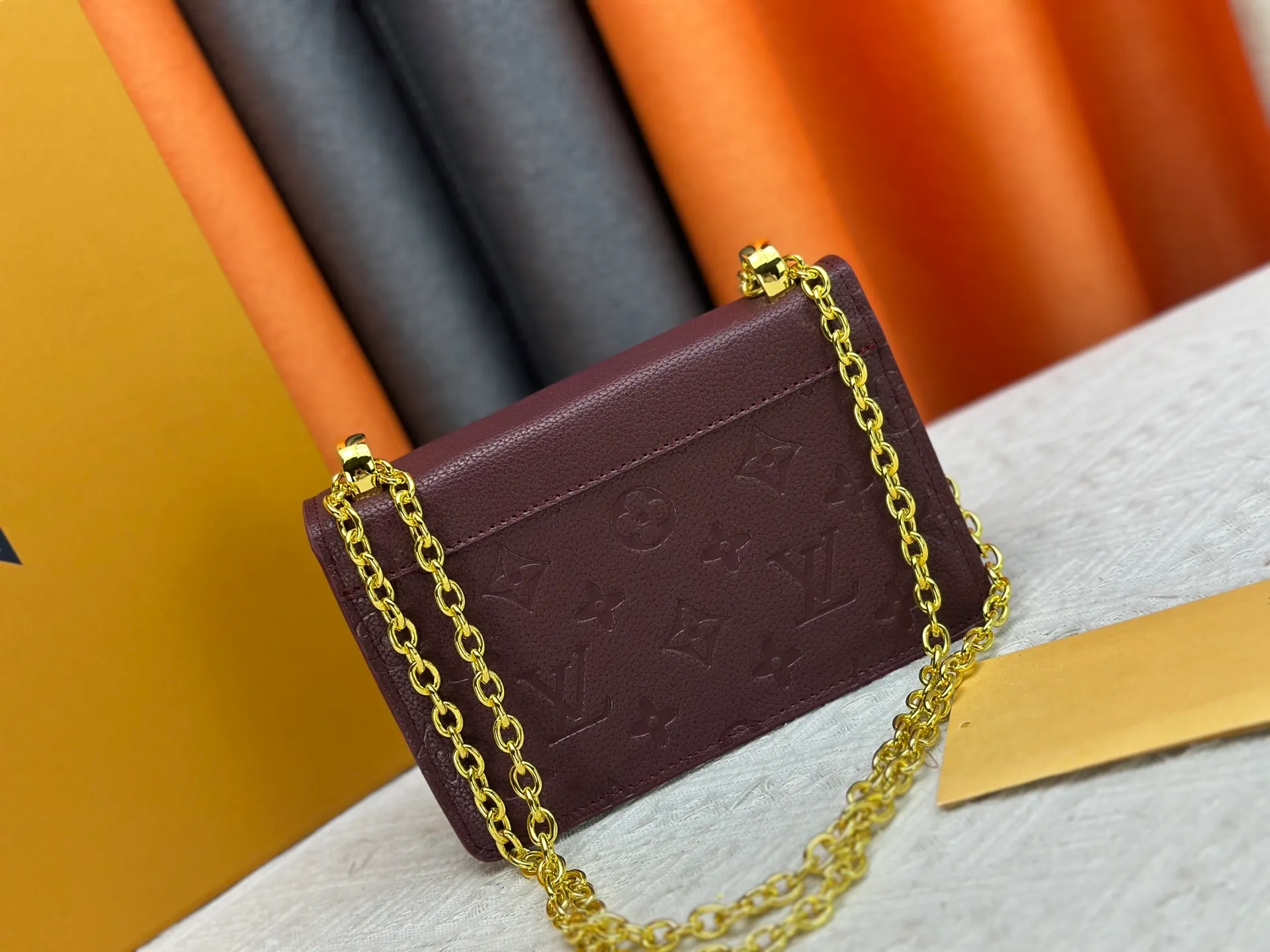 P220 M13569 black M13570 gray M25814 burgundy (chain/embossed) [Portefeuille chaîne Rosy] This Rosy chain wallet is both fashionable and practical, adding a modern spirit to the Monogram Empreinte series. It has an elegant LV circle and a V-shaped flap, two hallmarks of the house. The magnetic closure reveals a surprise Monogram flower, as well as three card slots and a flat interior pocket. The sliding chain allows you to wear it crosswise or over the shoulder.  Dimensions: 19.5 x 13.5 x 6.5 cm