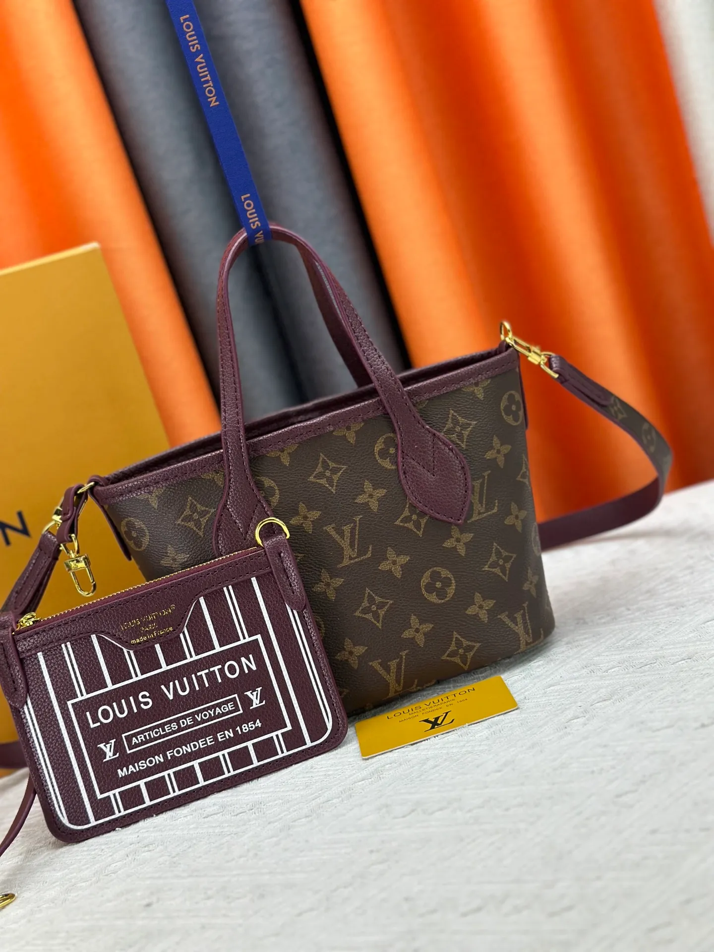 P250 M25656 M12099 Upgraded original Neverfull Bandouliere Inside Out BB handbag is a double-sided version of the classic design this season, with the front and back decorated with iconic Monogram canvas and grained leather. The removable zipper bag can be used alone or hung externally. The detachable shoulder strap makes it easy to wear cross-body, and the dazzling metal hardware adds a sophisticated detail. Dimensions: 26.5 × 16.5 × 11 cm