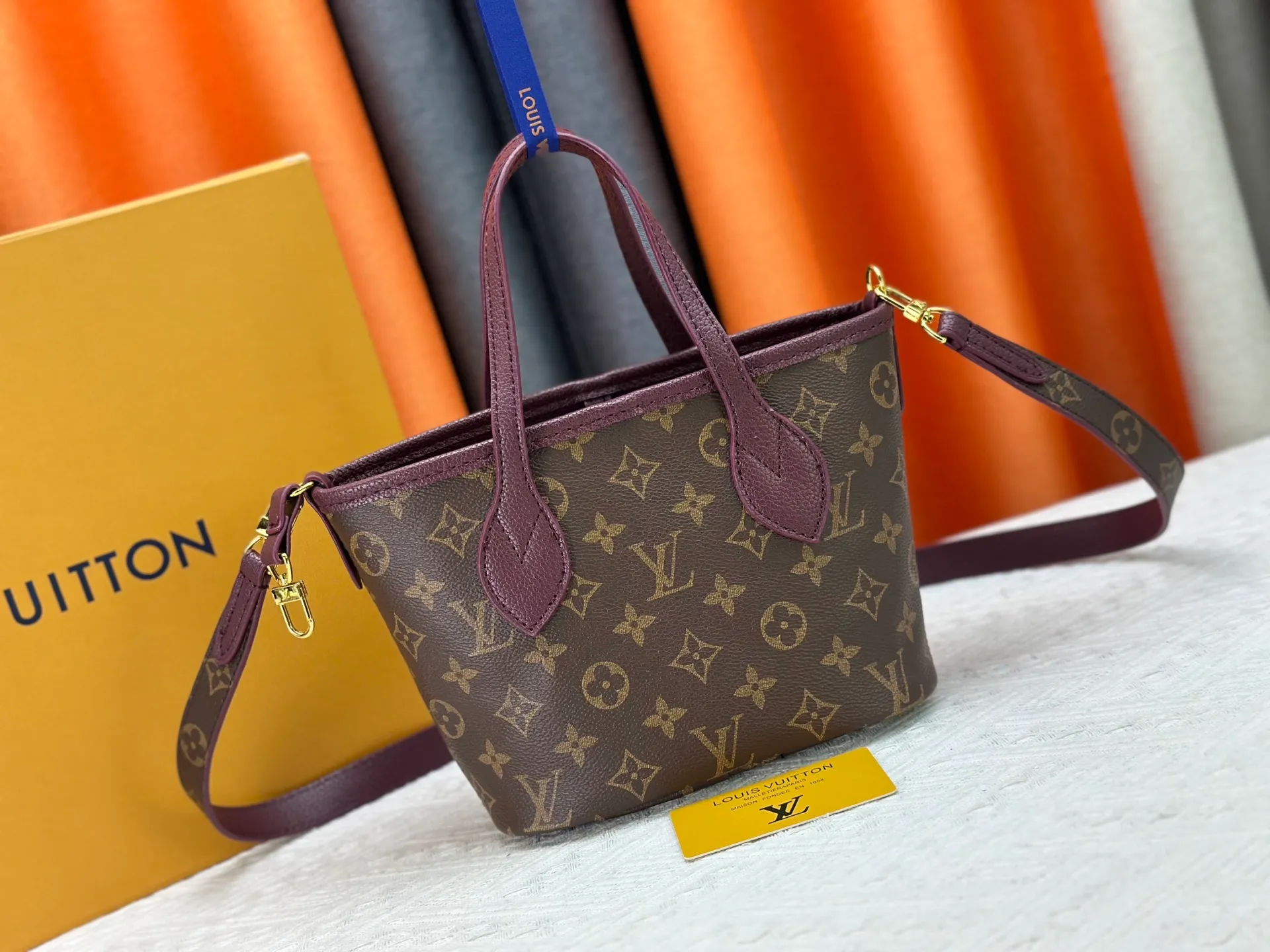 P250 M25656 M12099 Upgraded original Neverfull Bandouliere Inside Out BB handbag is a double-sided version of the classic design this season, with the front and back decorated with iconic Monogram canvas and grained leather. The removable zipper bag can be used alone or hung externally. The detachable shoulder strap makes it easy to wear cross-body, and the dazzling metal hardware adds a sophisticated detail. Dimensions: 26.5 × 16.5 × 11 cm