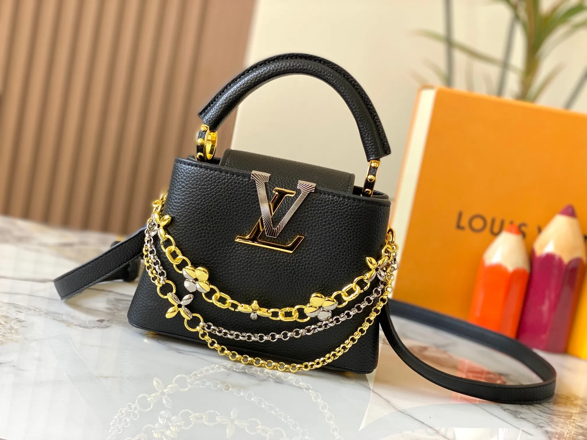 P480 [Guangzhou top quality original version] M26351 Black Gold This modern version of Capucines mini is made of timeless Taurillon leather and equipped with a jewelry-inspired Infinity chain. The bag is decorated with double galvanized metal parts, including the iconic Monogram floral pattern, and the LV Initials logo created with sunburst technology, creating a sundial-like light and shadow effect. The bag has multiple pockets and a detachable shoulder strap, allowing it to be carried on one shoulder or across the body. 14 x 8 x 21 cm (height x width x length)