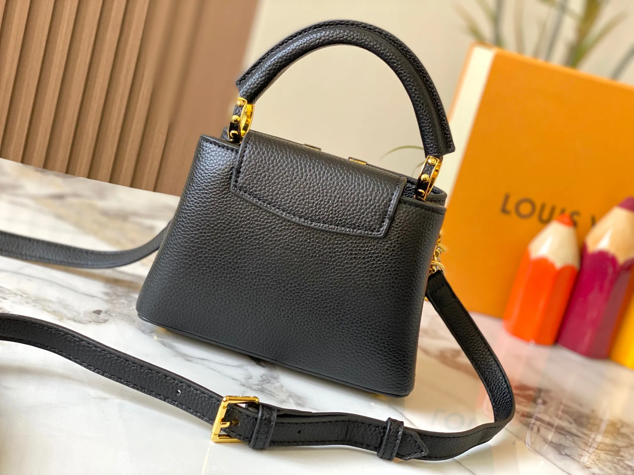 P480 [Guangzhou top quality original version] M26351 Black Gold This modern version of Capucines mini is made of timeless Taurillon leather and equipped with a jewelry-inspired Infinity chain. The bag is decorated with double galvanized metal parts, including the iconic Monogram floral pattern, and the LV Initials logo created with sunburst technology, creating a sundial-like light and shadow effect. The bag has multiple pockets and a detachable shoulder strap, allowing it to be carried on one shoulder or across the body. 14 x 8 x 21 cm (height x width x length)
