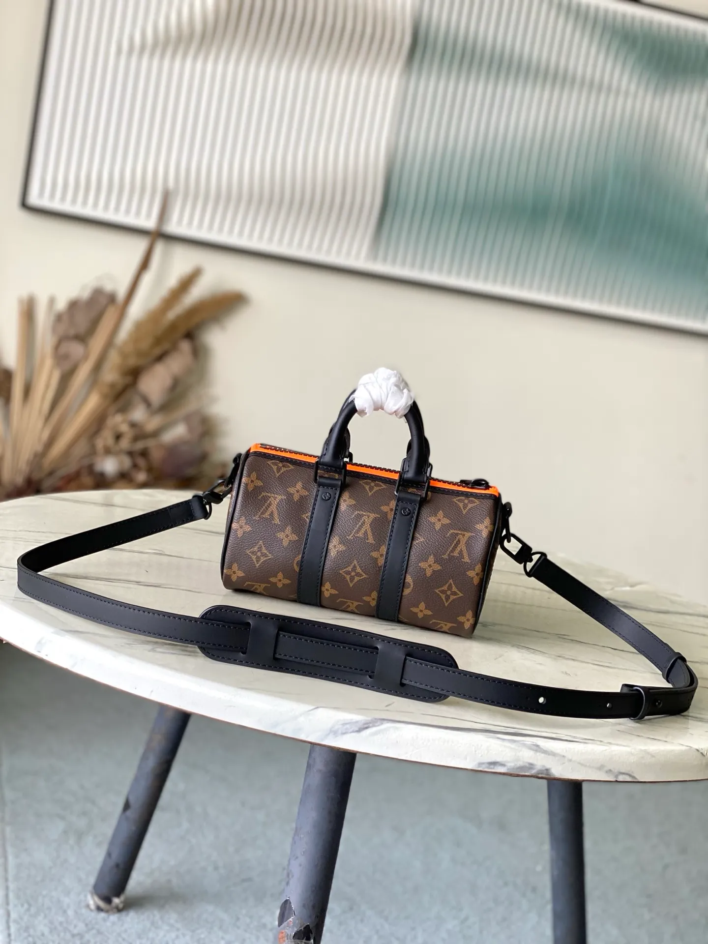 💰840 Top Original M80201 This Keepall Nano men's handbag is a compact version of the brand's original soft travel bag launched in 1930, combining Monogram canvas with black matte leather. A pop of neon orange next to the edge of the zipper makes this classic look pop. The embroidered patches feature cartoon characters from the “Zoom with friends” animated short created by menswear artistic director Virgil Abloh. Dimensions: 12 x 21 x 9 cm