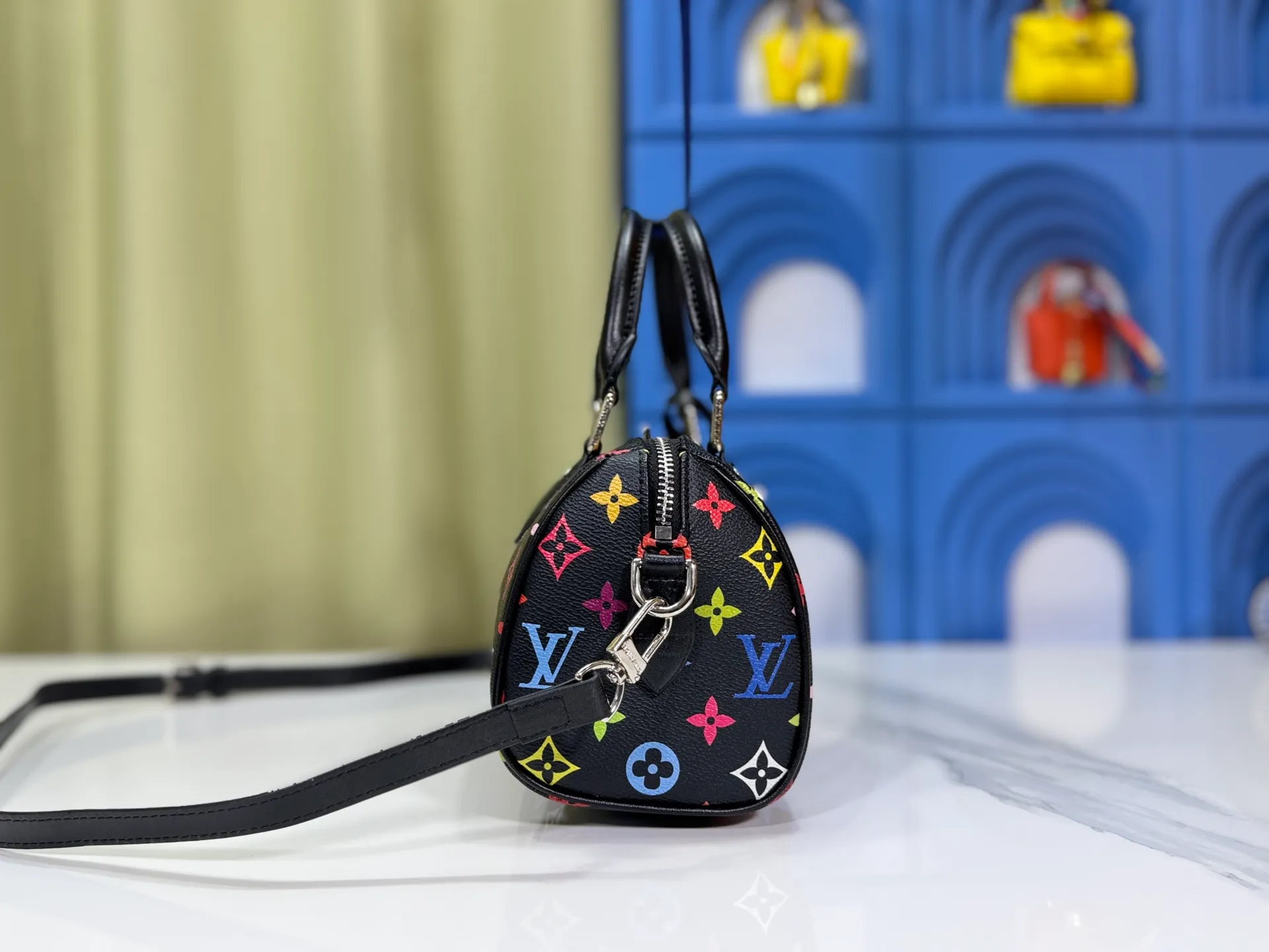 P260 Upgraded from the original version, this M46234 M46222 Speedy Bandoulière 20 handbag is made of soft coated canvas, with the full-length Monogram pattern traced in colorful rainbow tones, highlighting the smart style of the Louis Vuitton x Murakami reissue series. The Toron handle and detachable shoulder strap are constructed of cow leather, the metal corners recall classic luggage elements, and the bow-shaped key bag and padlock add brand touches. Dimensions: 20.5 x 13.5 x 12.0 cm (length x height x width)