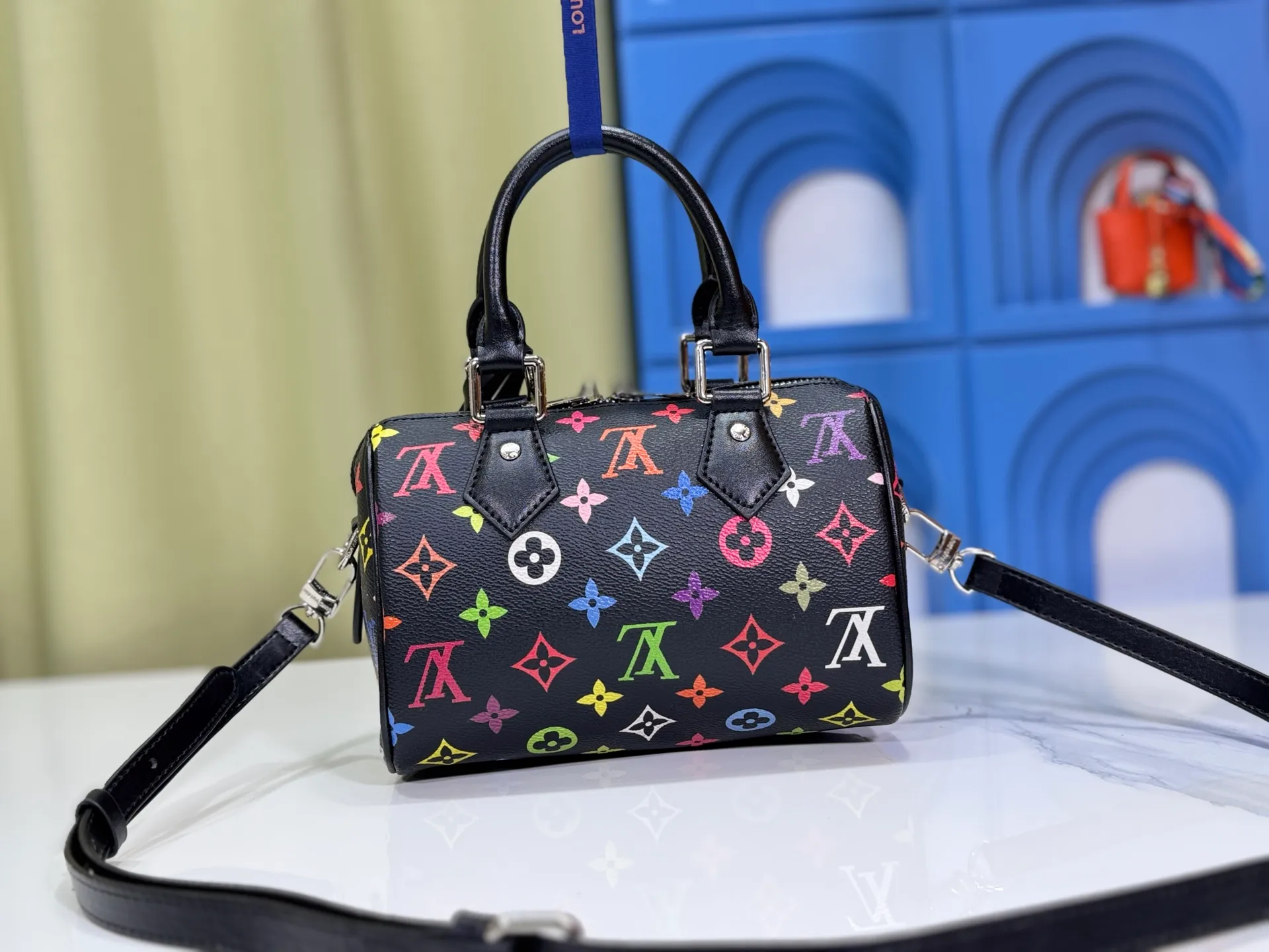 P260 Upgraded from the original version, this M46234 M46222 Speedy Bandoulière 20 handbag is made of soft coated canvas, with the full-length Monogram pattern traced in colorful rainbow tones, highlighting the smart style of the Louis Vuitton x Murakami reissue series. The Toron handle and detachable shoulder strap are constructed of cow leather, the metal corners recall classic luggage elements, and the bow-shaped key bag and padlock add brand touches. Dimensions: 20.5 x 13.5 x 12.0 cm (length x height x width)