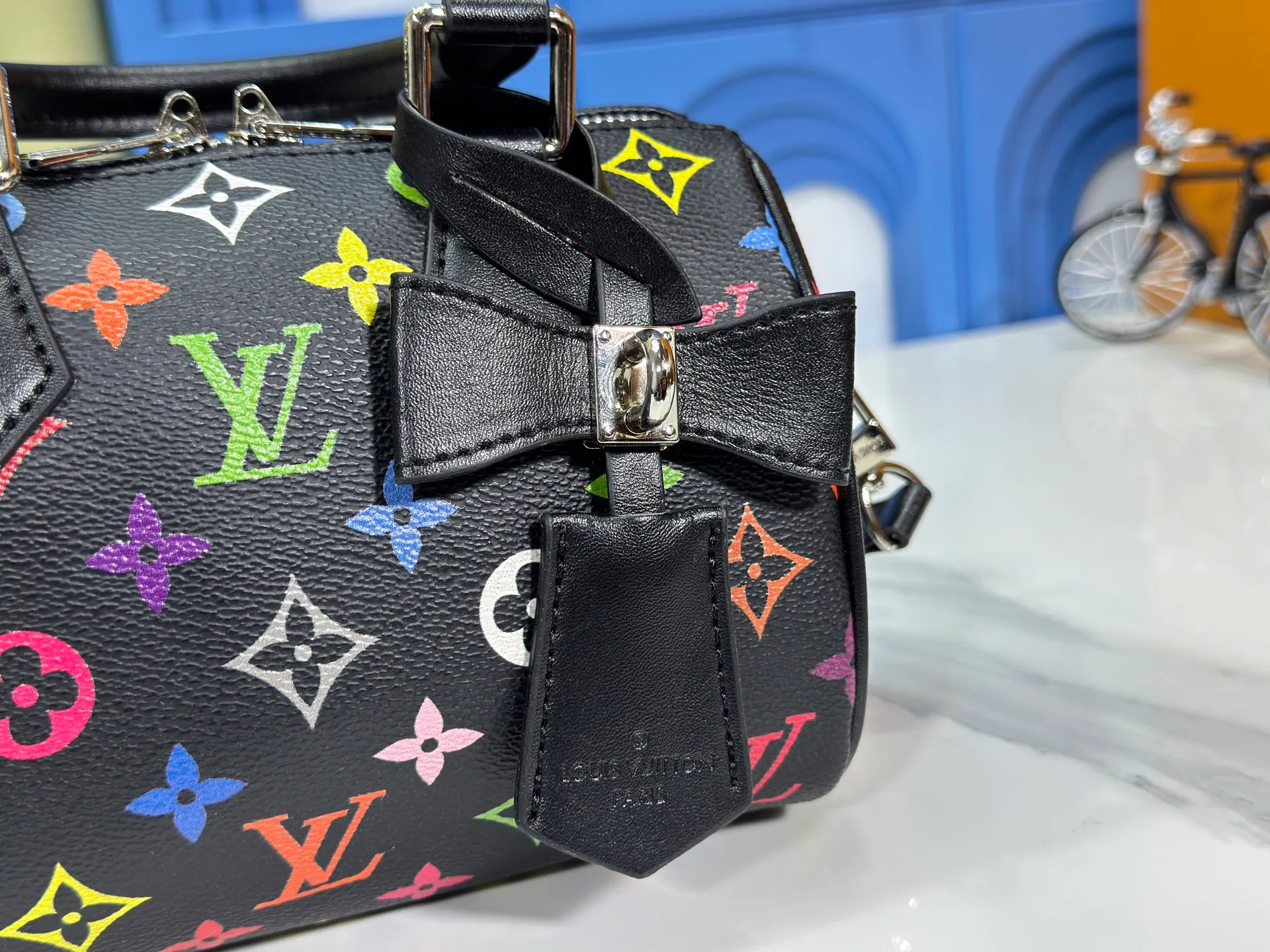 P260 Upgraded from the original version, this M46234 M46222 Speedy Bandoulière 20 handbag is made of soft coated canvas, with the full-length Monogram pattern traced in colorful rainbow tones, highlighting the smart style of the Louis Vuitton x Murakami reissue series. The Toron handle and detachable shoulder strap are constructed of cow leather, the metal corners recall classic luggage elements, and the bow-shaped key bag and padlock add brand touches. Dimensions: 20.5 x 13.5 x 12.0 cm (length x height x width)