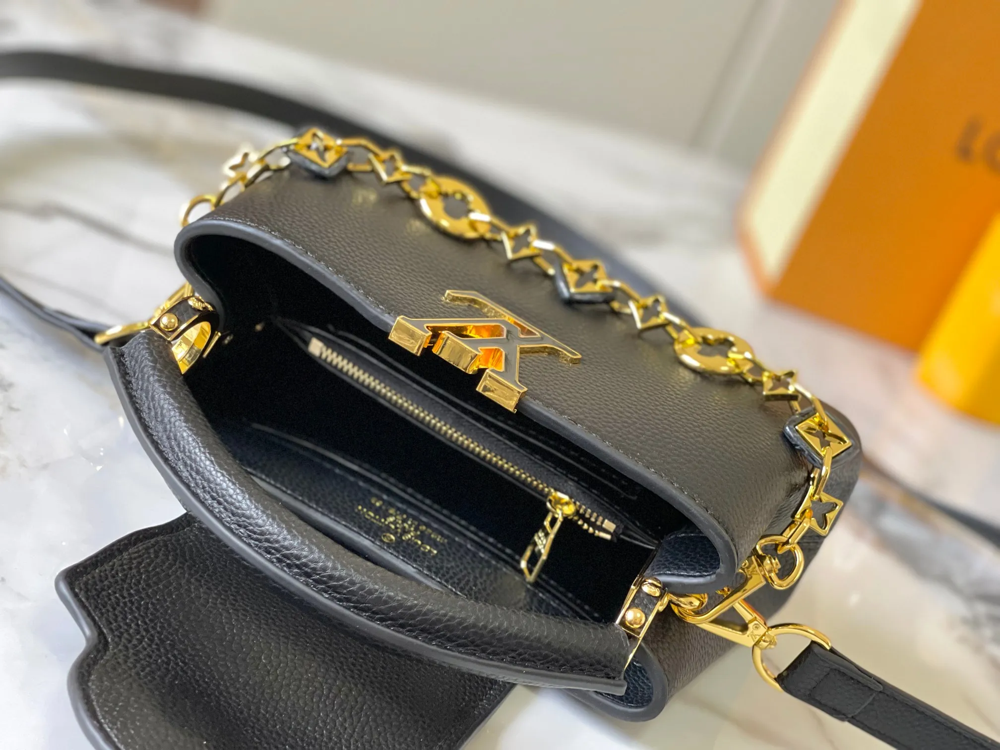 p460 [Guangzhou top quality original] M14393 black CapucinesEastWest mini handbag, with a decorative chain showing the inspiration of Monogram flowers. Taurillon cow leather creates an exquisite structure, and the LV letters interpret the colorful brushstrokes of the Puffygram jewelry series. The flap can be folded in or out, and the inner pocket can safely store valuables. Size:22×12×8cm