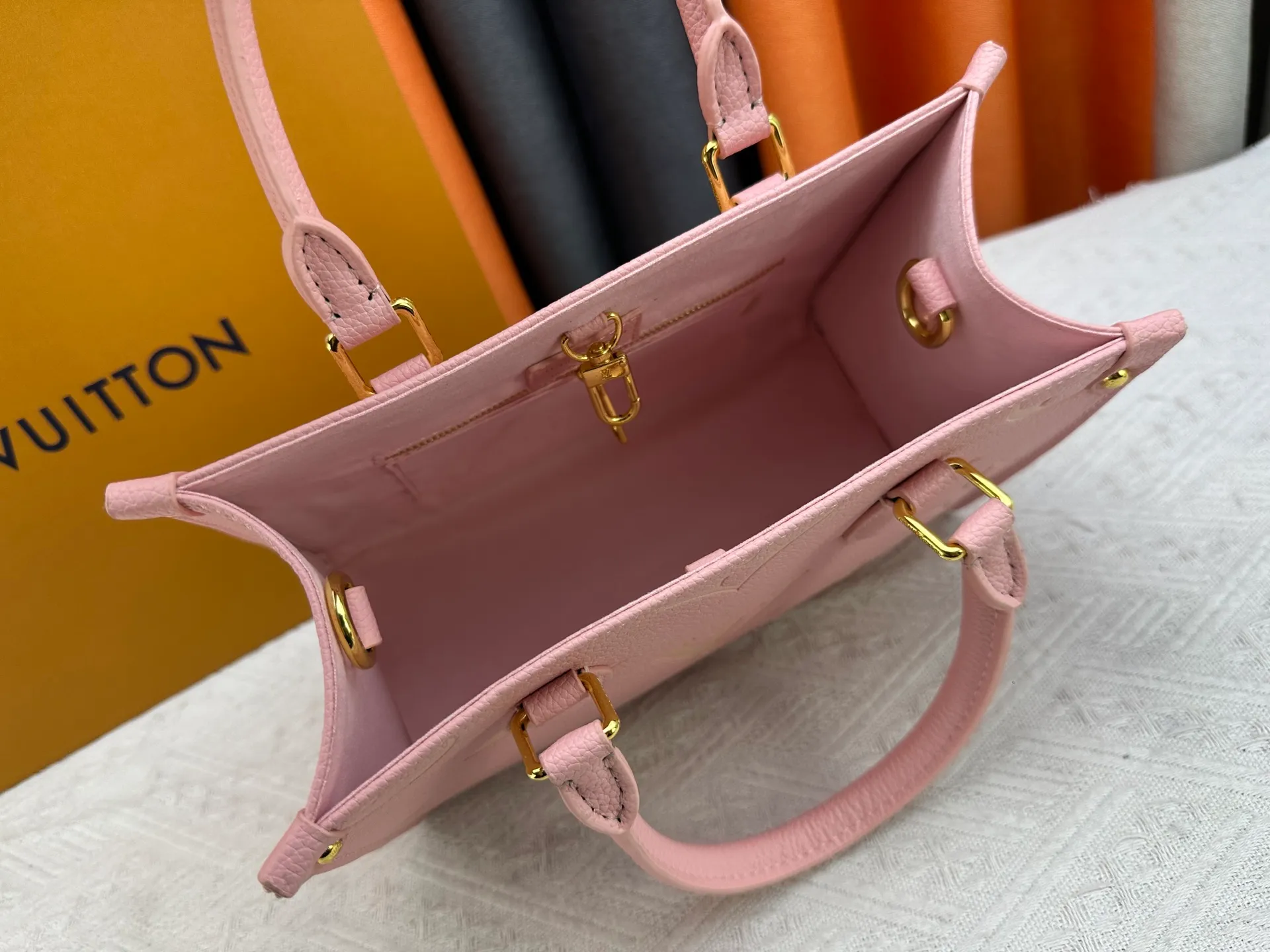 P240 Upgraded original version M12465 M12775 M45659 M45607 MM45595 M46531 M45495 This Monogram Ink series OnTheGo medium handbag has a matte texture of smooth cow leather, and the rivet tabs on the corners pay tribute to the brand's classic hard box design. The neat interior has a large zipper pocket for storing banknotes and receipts. Dimensions: 25 x 19x 11 cm (length x height x width)