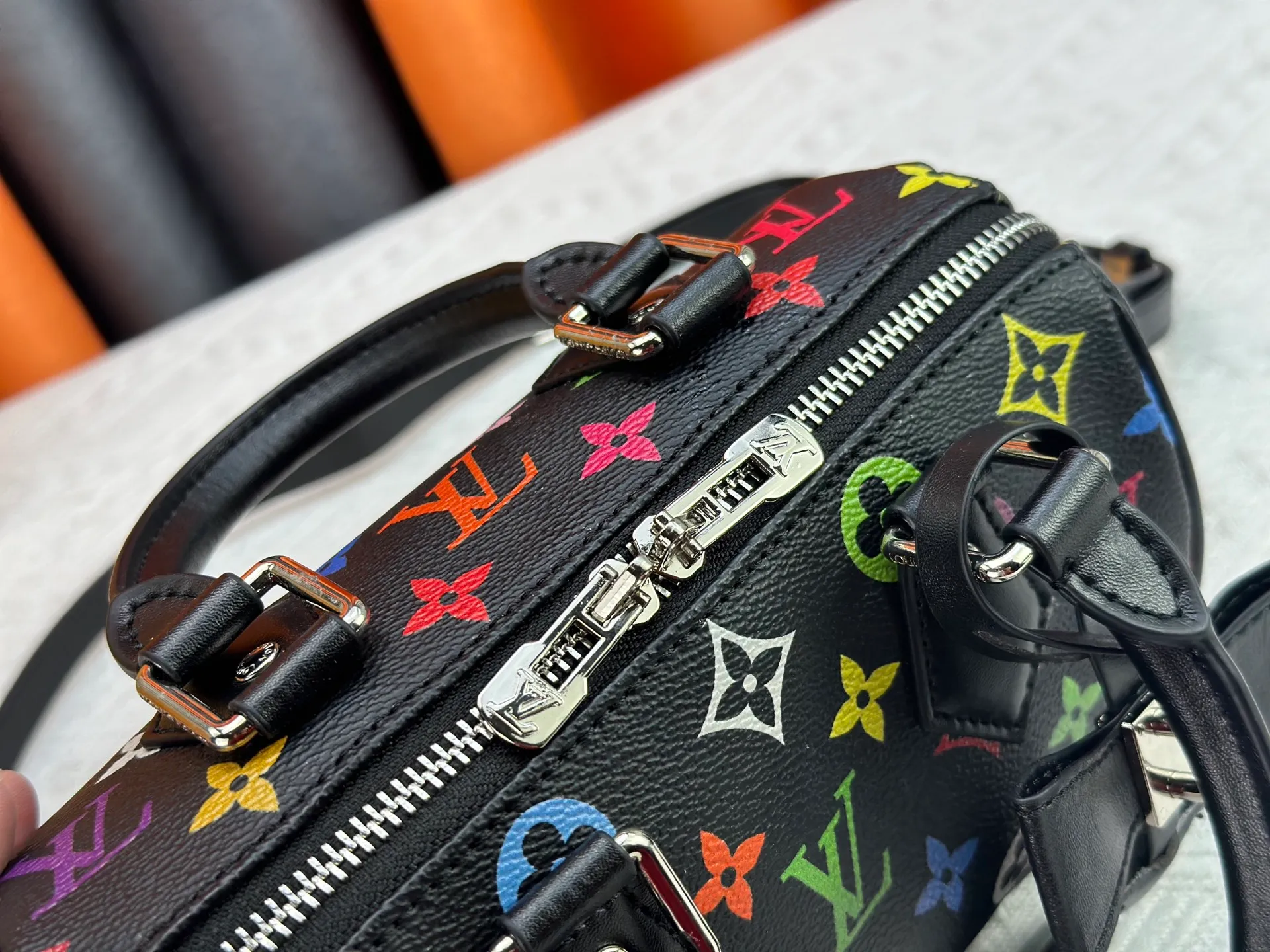 P260 Upgraded from the original version, this M46234 M46222 Speedy Bandoulière 20 handbag is made of soft coated canvas, with the full-length Monogram pattern traced in colorful rainbow tones, highlighting the smart style of the Louis Vuitton x Murakami reissue series. The Toron handle and detachable shoulder strap are constructed of cow leather, the metal corners recall classic luggage elements, and the bow-shaped key bag and padlock add brand touches. Dimensions: 20.5 x 13.5 x 12.0 cm (length x height x width)