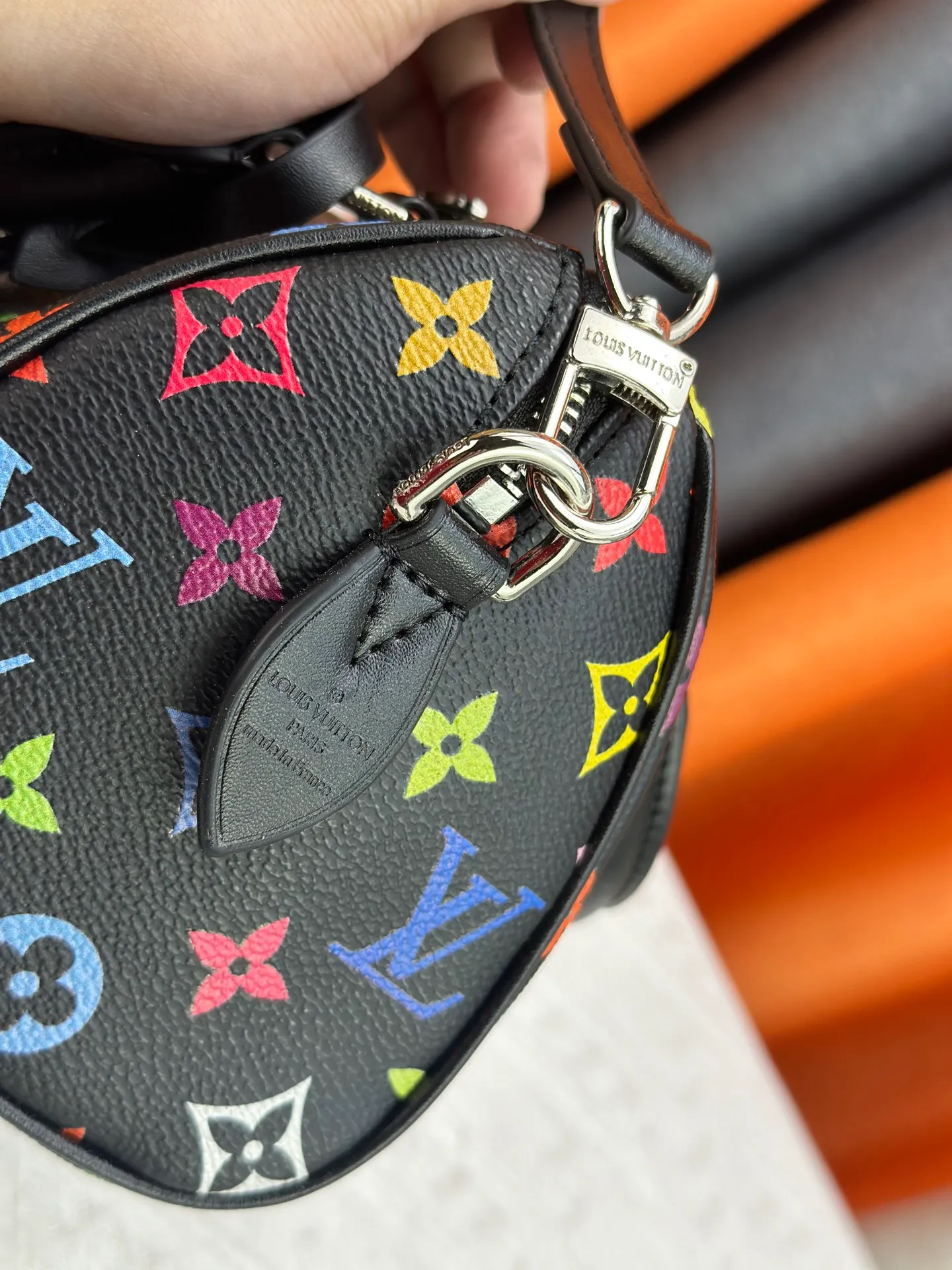 P260 Upgraded from the original version, this M46234 M46222 Speedy Bandoulière 20 handbag is made of soft coated canvas, with the full-length Monogram pattern traced in colorful rainbow tones, highlighting the smart style of the Louis Vuitton x Murakami reissue series. The Toron handle and detachable shoulder strap are constructed of cow leather, the metal corners recall classic luggage elements, and the bow-shaped key bag and padlock add brand touches. Dimensions: 20.5 x 13.5 x 12.0 cm (length x height x width)